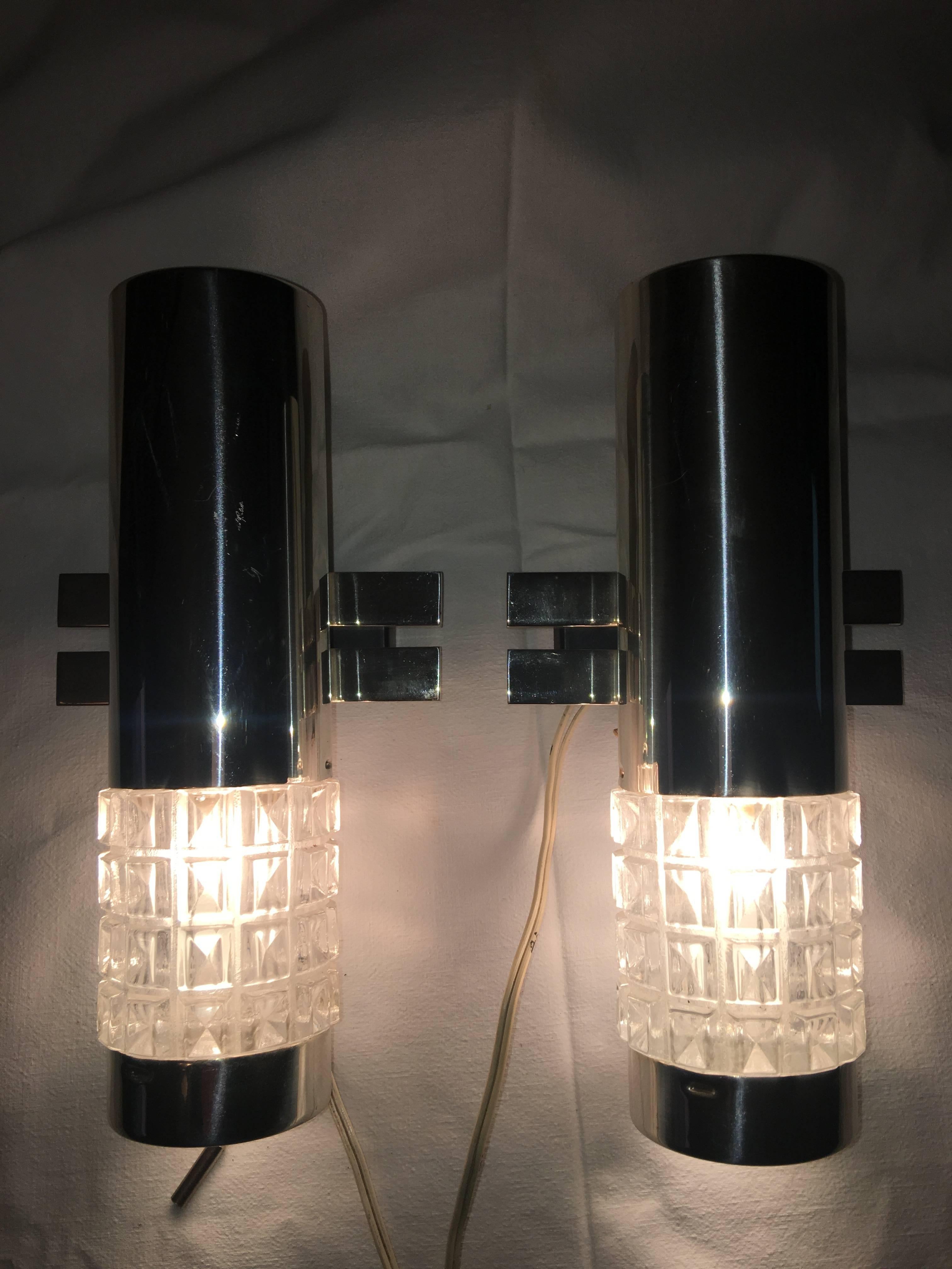 From Kaiser Leuchten of Germany. A pair of great looking 1960s chrome and glass Kaiser sconces. Equipped with on/off switch. Each requires one European E14 candelabra bulb max 40 W. Item will be shipped directly from Germany to buyer.