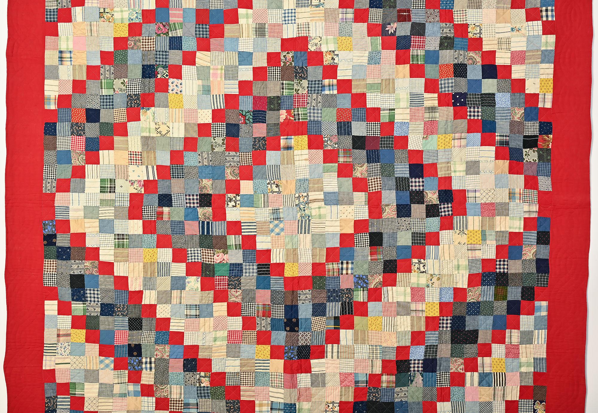 This Barnraising pattern quilt is made with One Patches rather than the usual Log Cabin strips. The sold reds against the printed fabrics make a very strong statement. The prints are a combination of stripes; plaids; calicoes and florals. Somehow,