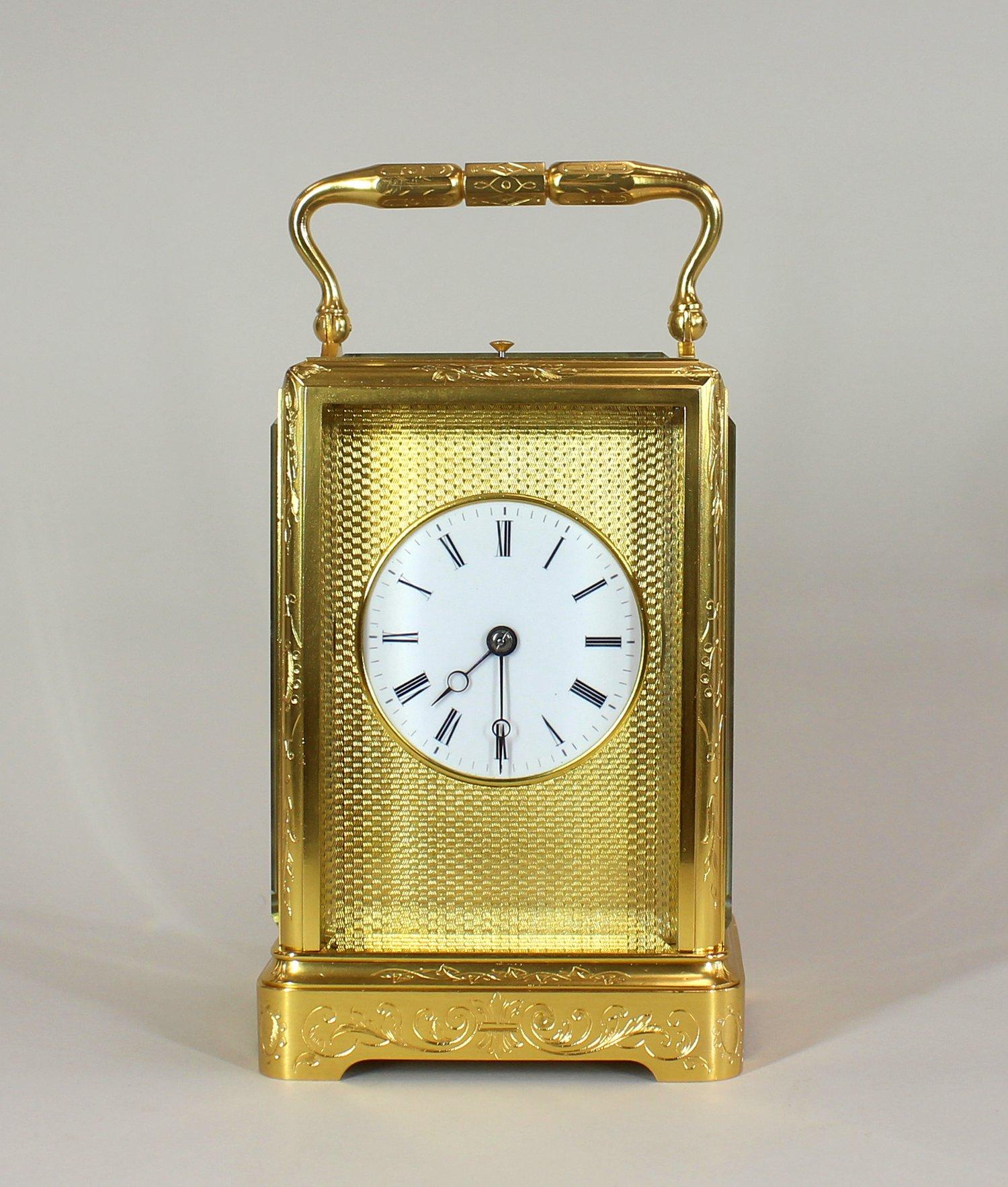 A fine early repeating carriage clock in an engraved one piece case. With a gilt engin turned mask, and a white enamel dial and roman numerals.

The gilded case is engraved with foliate scrollwork, the 8 day repeating movement with English lever