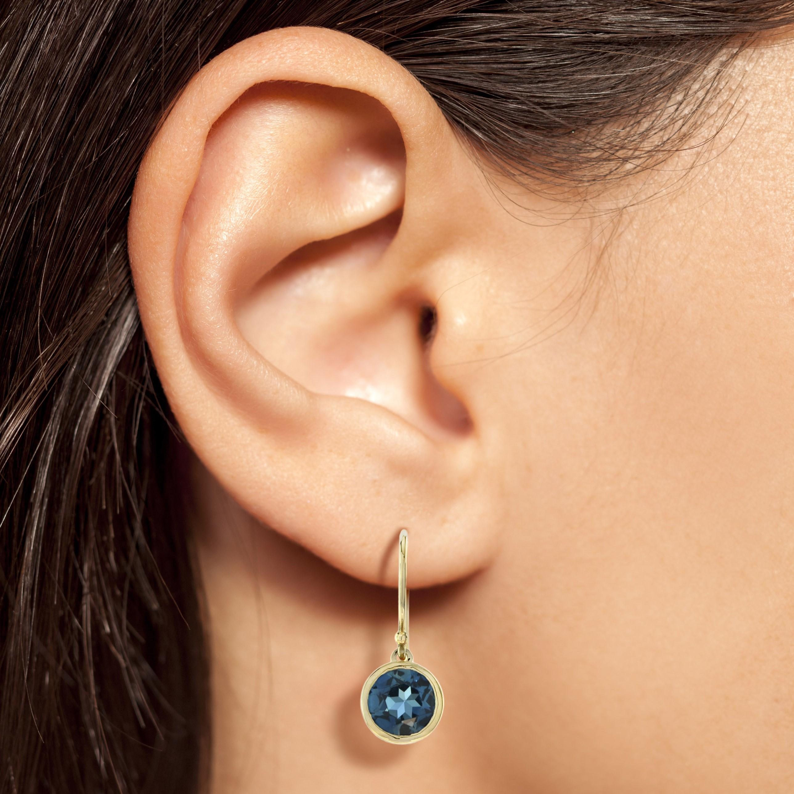 These lovely yellow gold earrings are set with a vibrant round cut London blue topaz, 7mm in diameter they are set into a yellow gold rim setting which hangs from a yellow gold hook fitting. A perfect gift for your beloved one.

Information
Metal: