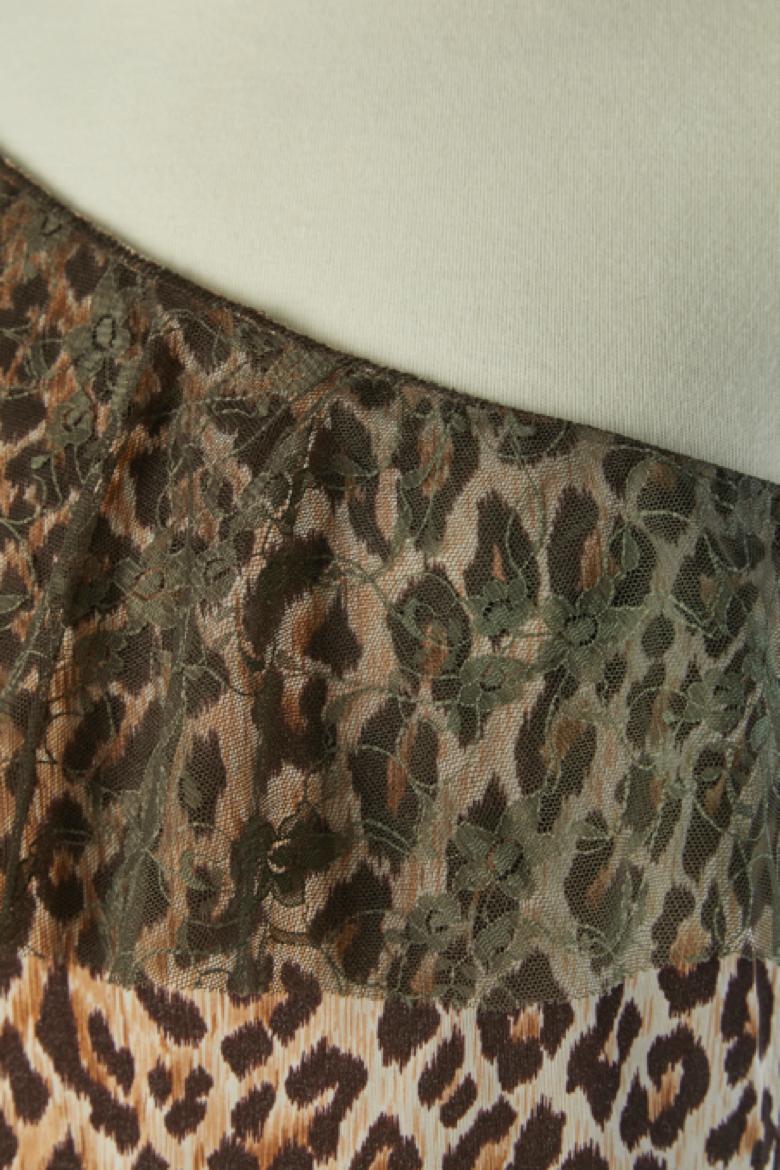 Top à une épaule avec imprimé animalier et bord en dentelle. Pas d'étiquette de composition du tissu, mais il s'agit de jersey extensible. 
TAILLE M