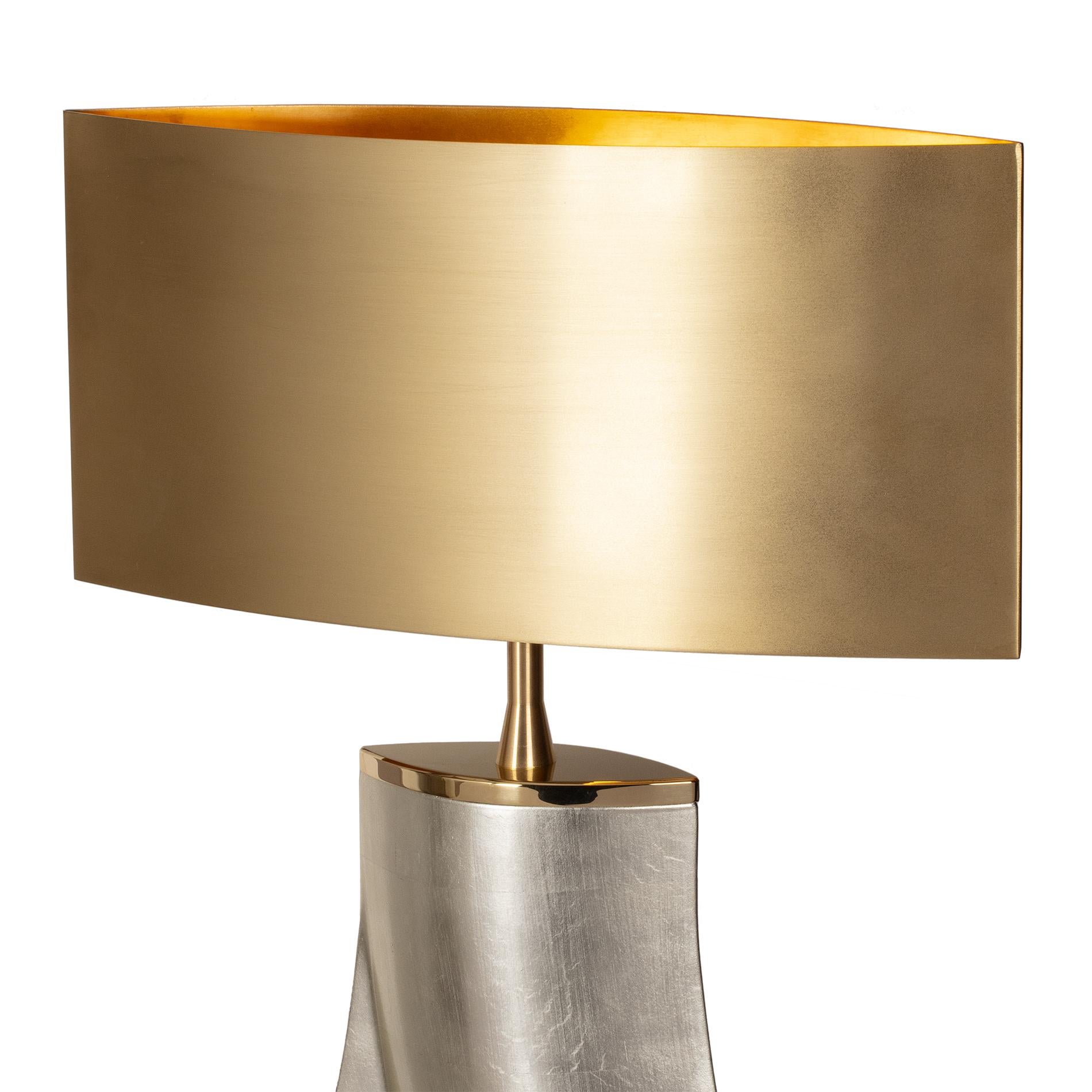 Table lamp one step with casted aluminum structure with
white gold leaf finish. With solid polished brass base and with
solid brushed brass shade. With 1 bulb, lamp holder type E27,
max 60 watt. Bulb not included.
