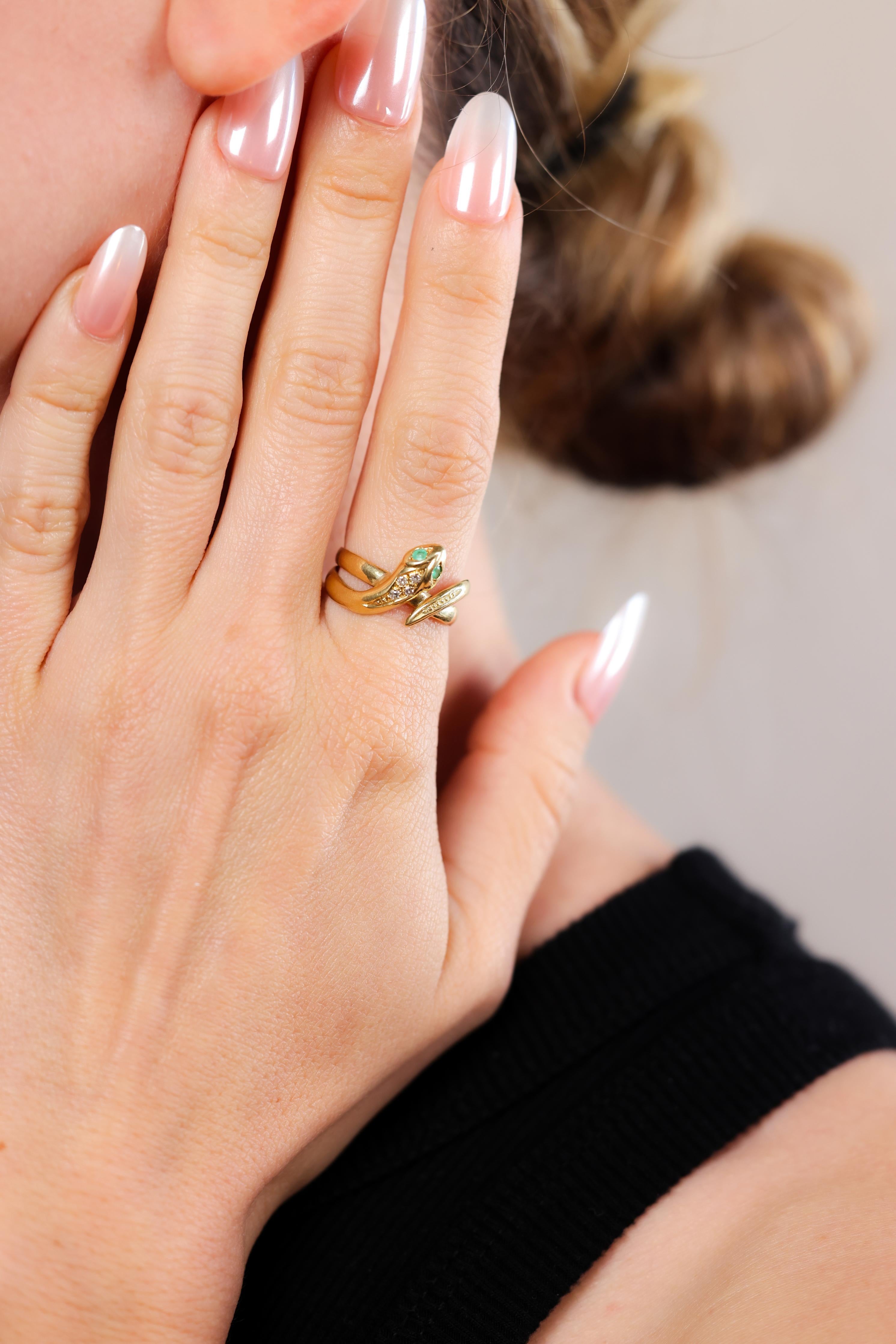 One Vintage Austrian Emerald Diamond 14k Yellow Gold Snake Ring. Featuring two round cut emeralds with a total weight of approximately 0.05 carat. Accented by four single cut diamonds with a total weight of approximately 0.05 carat, graded F color,