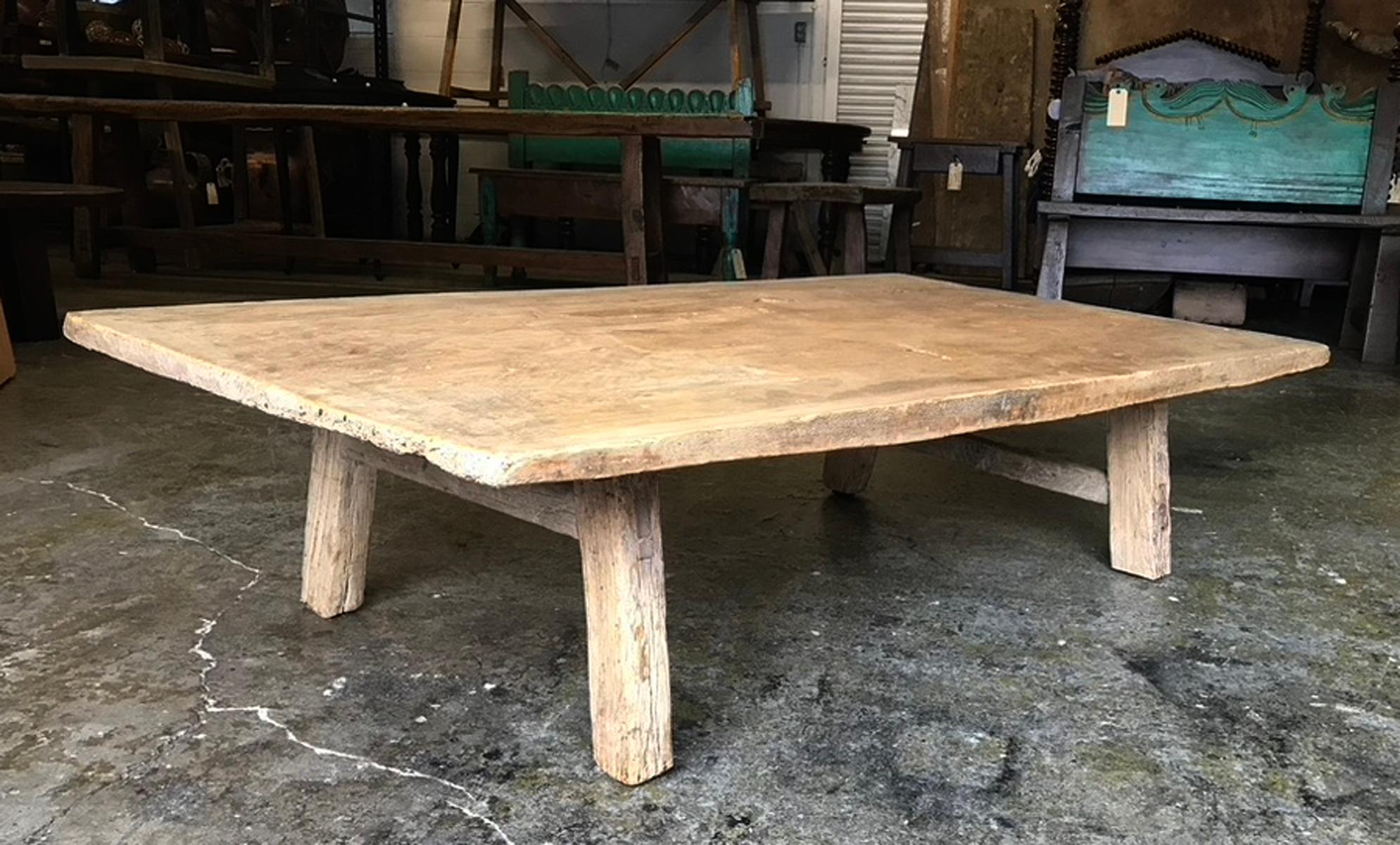 This coffee table consists of a naturally aged, one wide board, hand hewn 19th century top. The patina is smooth and beautiful. The wood is a light honey color. Legs have been added recently and finished to match this top. Knots and natural age