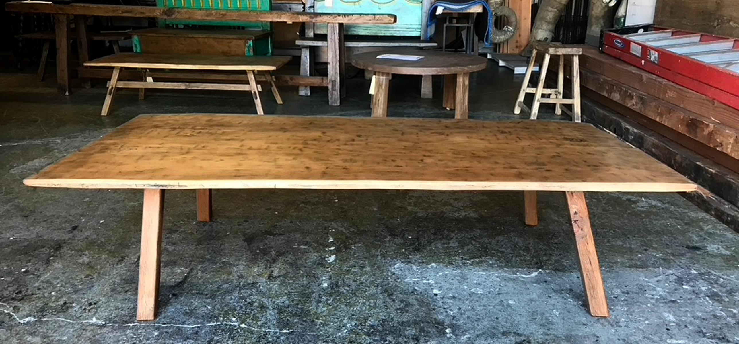 Table basse rustique composée d'une planche large ancienne, taillée à la main, provenant du Guatemala, sur des pieds contemporains, dont la finition est assortie au plateau. Le dessus est très patiné et intéressant. Il montre une usure appropriée à