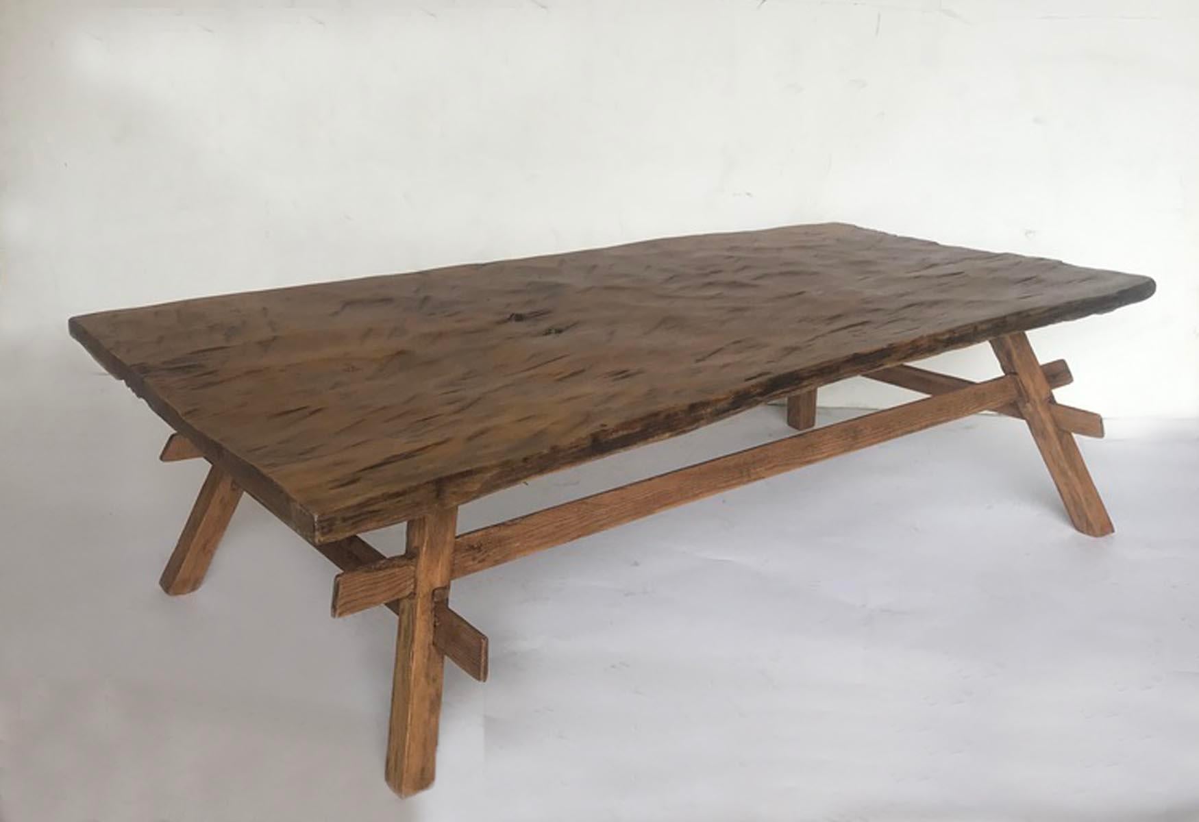 Rustic coffee table made from an antique, one wide board top and newer legs. Top is hand hewn. Table top is slightly warped but it does not take away from being a functional table.