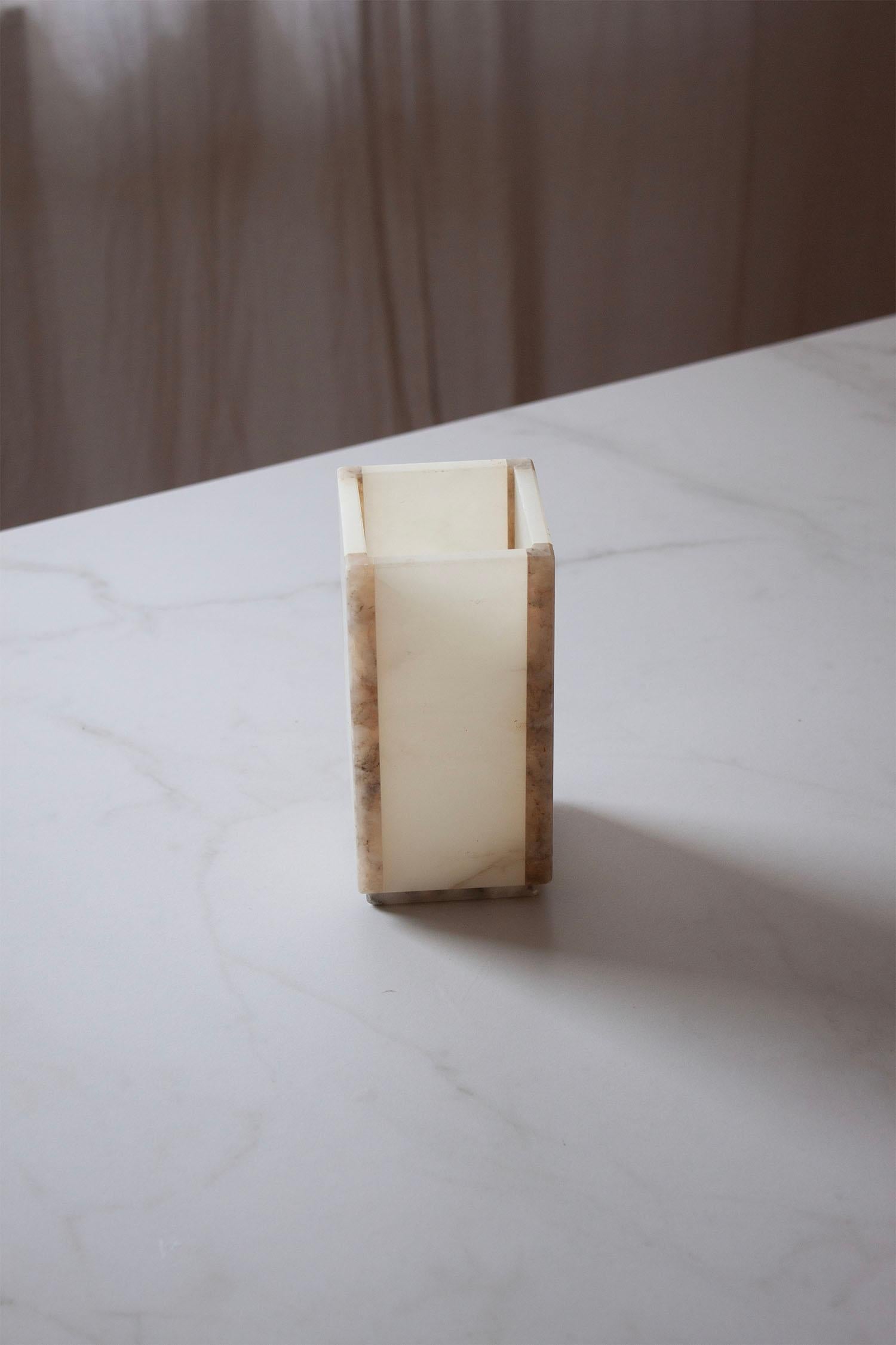 This marble and onyx vessel is a functional and stylish addition to any space. Hand-carved from natural stone, each piece has its own unique veining and color variations, making it a one-of-a-kind item. The smooth, polished surface and solid weight