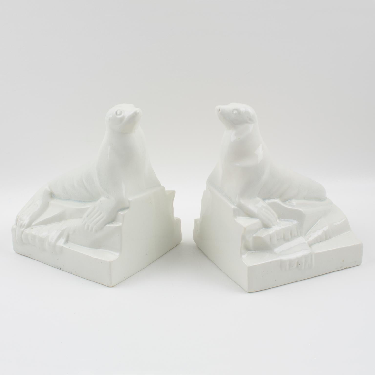 These stylish Art Deco crackled ceramic bookends were created and manufactured by Onnaing, France, in the 1920s. The off-white colored, crackle-glaze ceramic or faience sculpture features a pair of seals or sea lions in a stylized cubist design. The