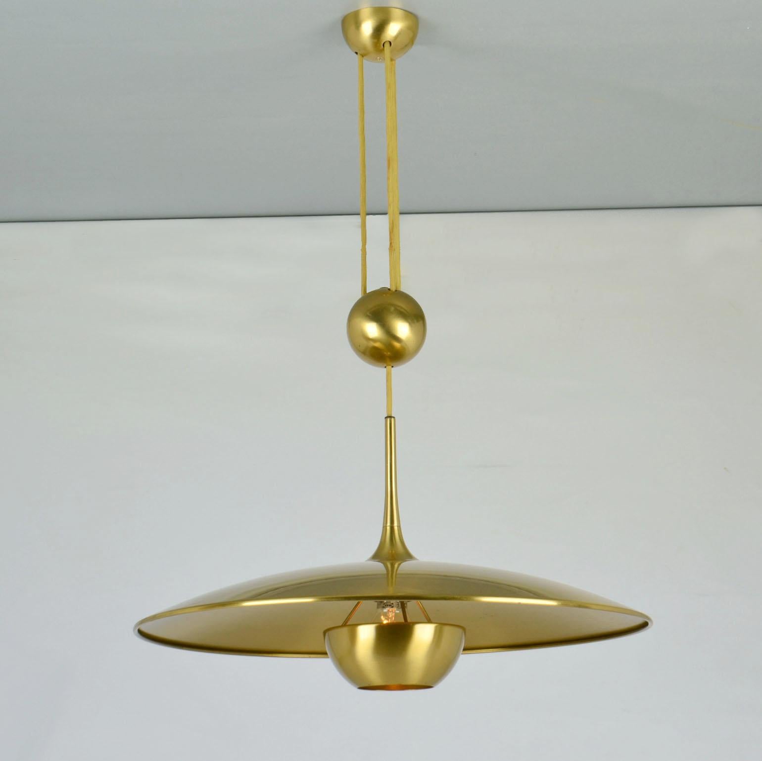 Original counterbalance pendant Onos 55 by Florian Schulz. This elegant and minimal pendant in a high quality brass moves smoothly up and down due to the solid brass  center counterweight. The shade was a brass diffuser. 
Excellent timeless design