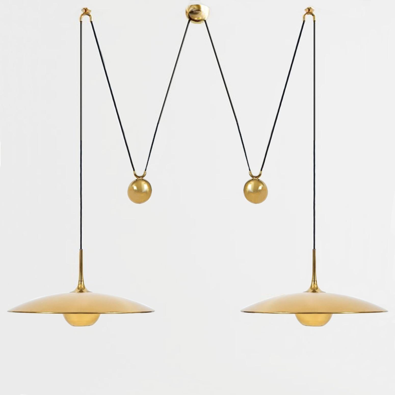 Fantastic Onos-55 Double Pull pendant light by Florian Schulz, Germany, Europe. Design period: 1970-1979, production period: 2022.

Two brass polished unlacquered pendants suspended with their own brass ball counter balance. One canopy supports