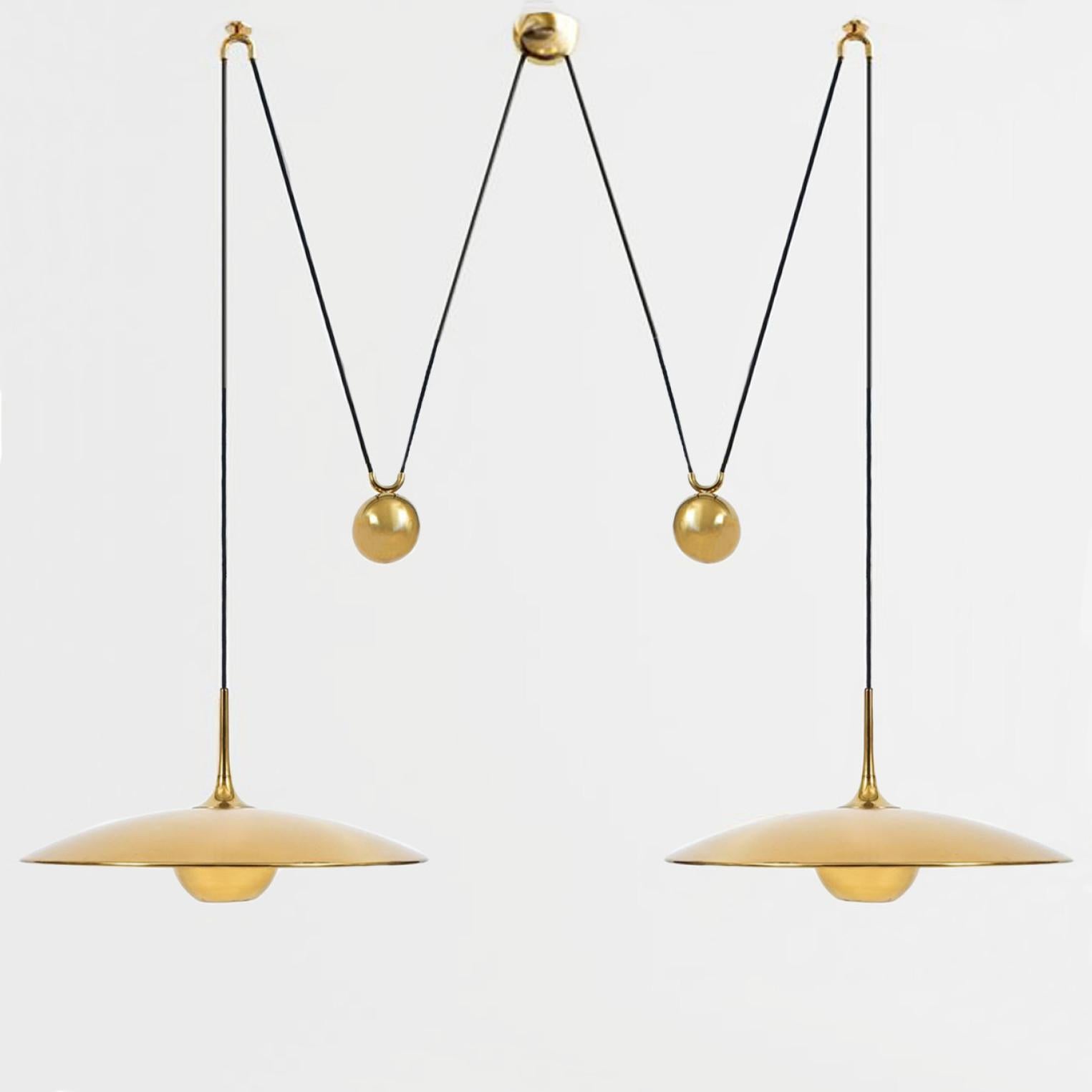 Fantastic pendant light Onos-55 Double Pull  by Florian Schulz, Germany, Europe. Design period: 1970-1979, production period: 2022.

Two brass polished unlacquered pendants suspended with their own brass ball counter balance. One canopy supports