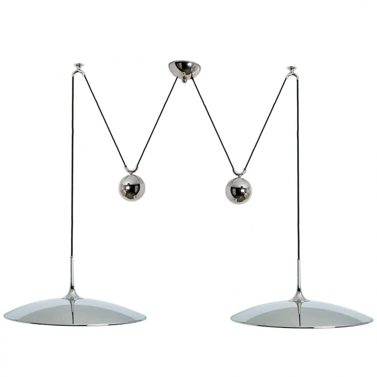 Fantastic pendant light Onos-55 Double Pull  by Florian Schulz, Germany, Europe. Design period: 1970-1979, production period: 2022.

Two nickel plated brass pendants suspended with their own brass ball counter balance. One canopy supports both