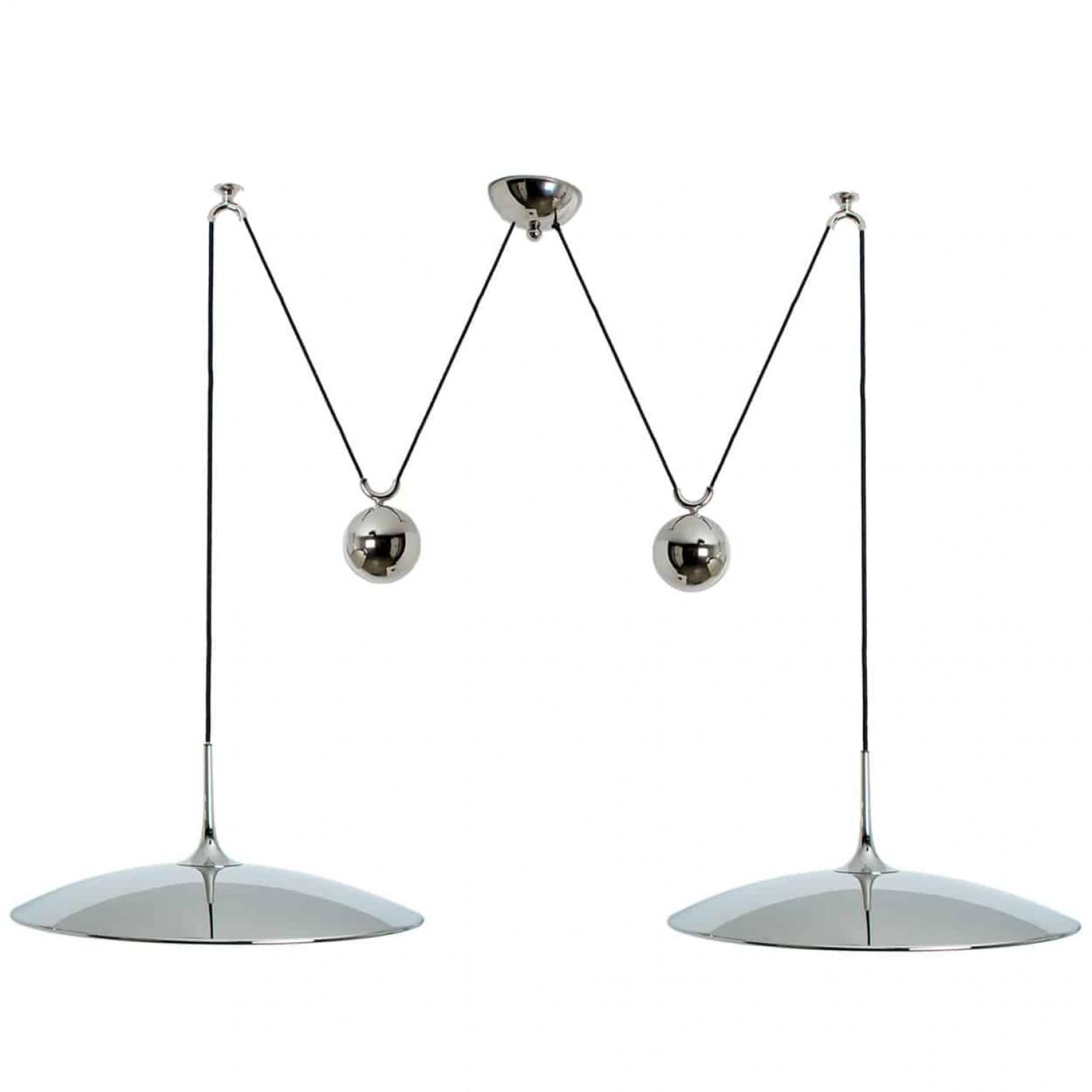 Fantastic pendant light Onos-55 Double Pull  by Florian Schulz, Germany, Europe. Design period: 1970-1979, production period: 2022.

Two nickel plated brass pendants suspended with their own brass ball counter balance. One canopy supports both