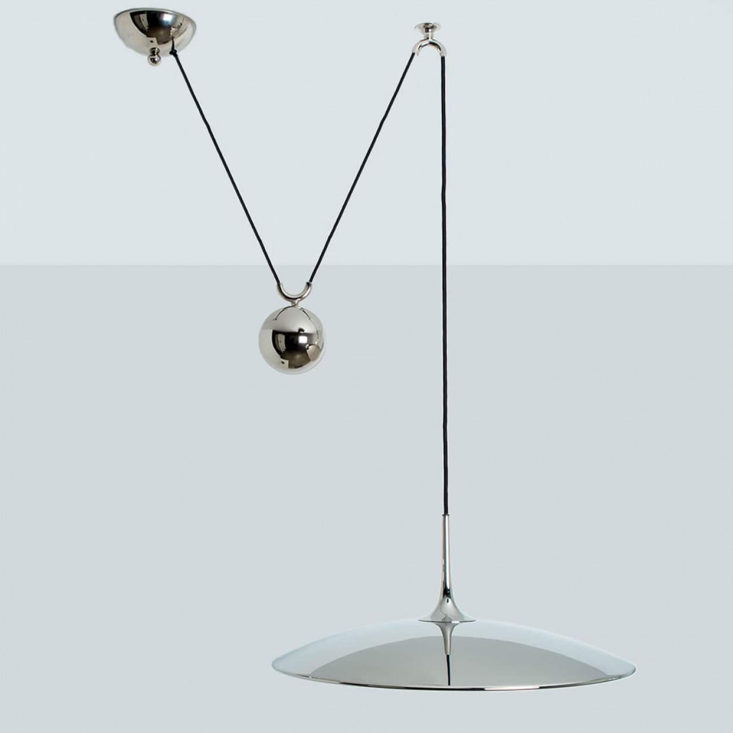 Fantastic Florian Schulz counter balance pendant by Florian Schulz. Design period: 1970-1979, production period: 2022.
The nickel plated brass pendant is suspended with his own nickel plated brass ball counter balance. One canopy supports the