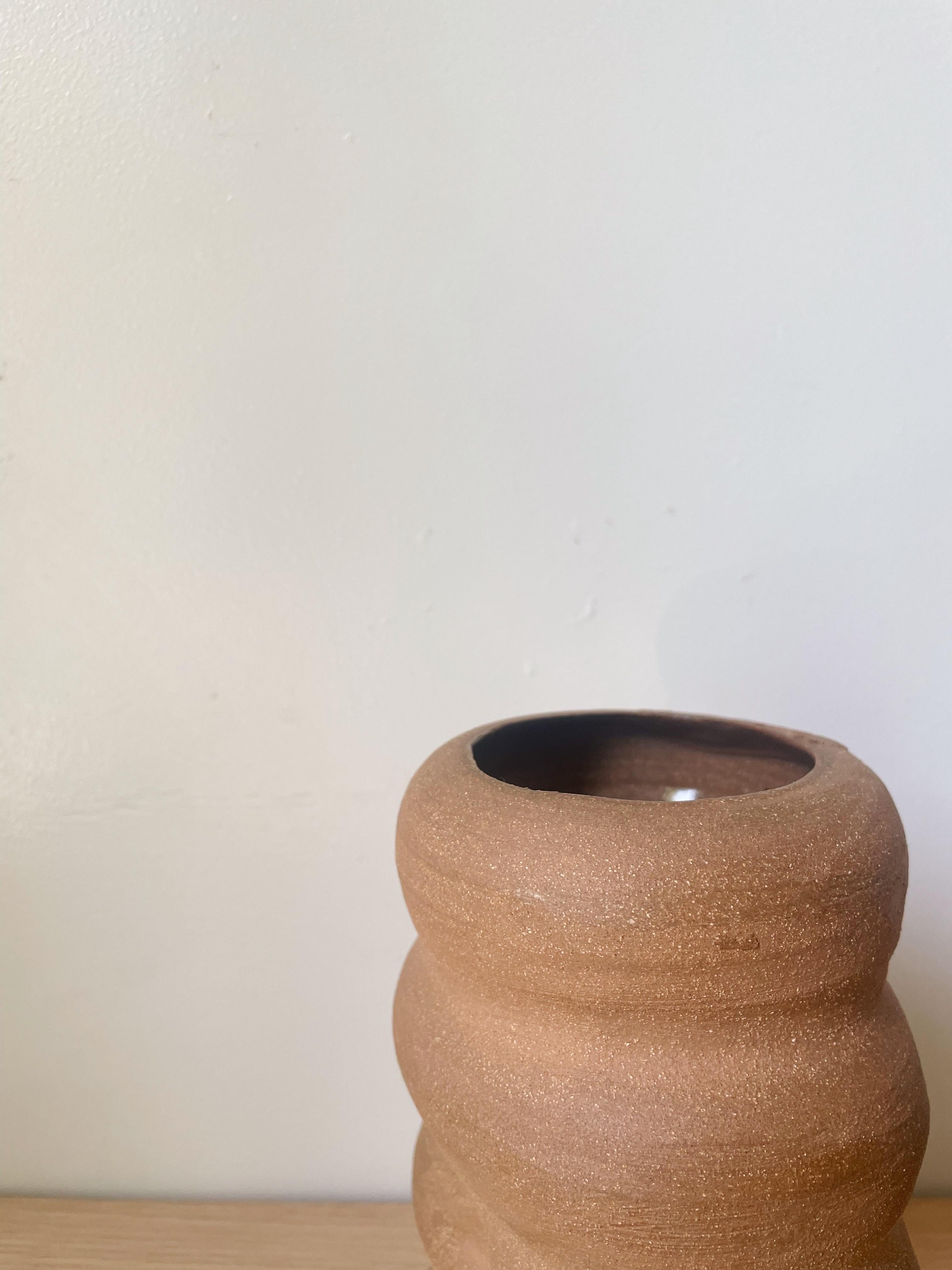 A raw hand thrown vessel. The vision with this piece, was to keep it simple and natural in its form and materiality. Stacking subtle lines of the exterior, paired with the indents on a few sides, creates an interesting overall look and feel. Sitting