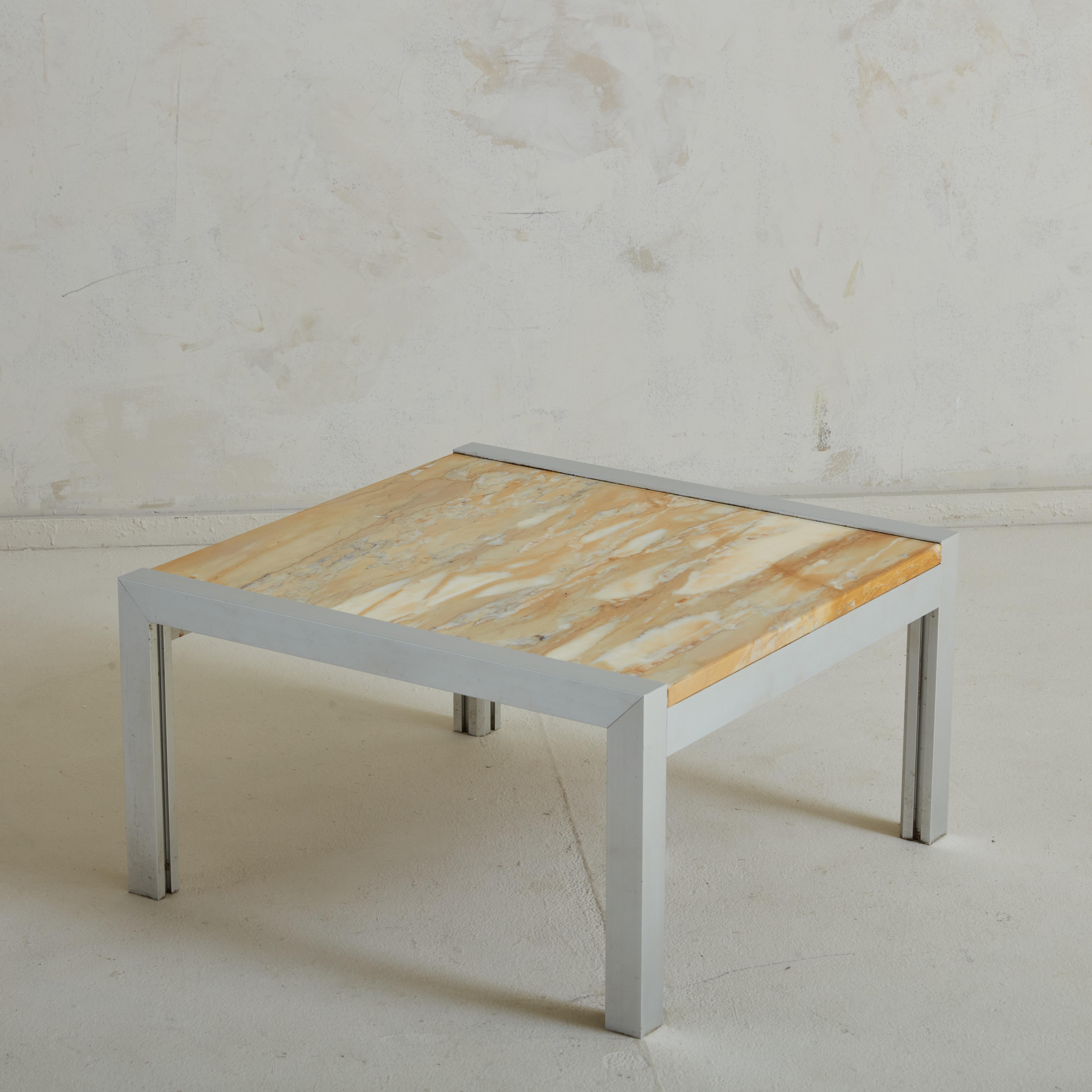 A 1970s French coffee table featuring a sleek aluminum frame with an inset onyx tabletop. This stone features an incredible range of peach hues, which contrast beautifully with the minimal lines of the base. Both simple and complex, this table is
