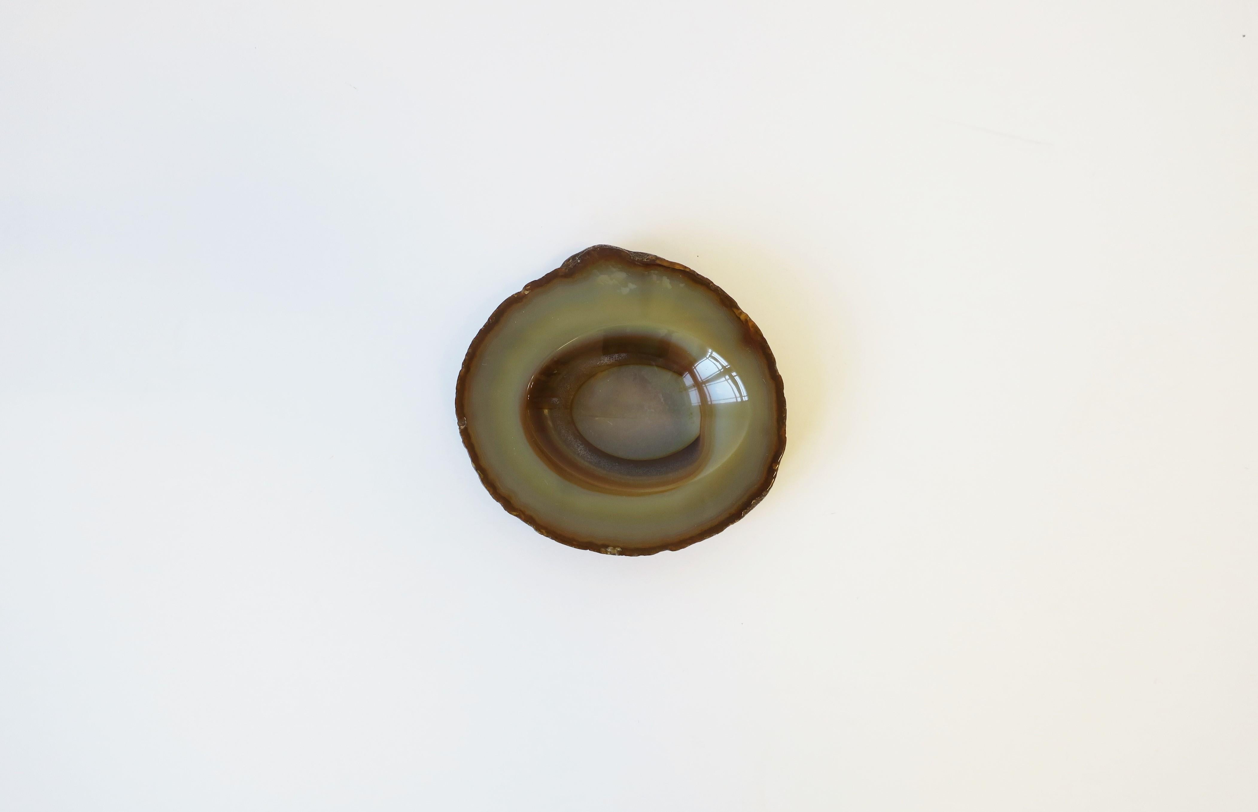A neutral onyx agate dish, decorative object, or small bowl/vessel. Piece can work as a small jewelry/trinket dish, a standalone decorative piece, or paperweight/desk accessory for small items, etc. Elegant and convenient for a table, office desk,