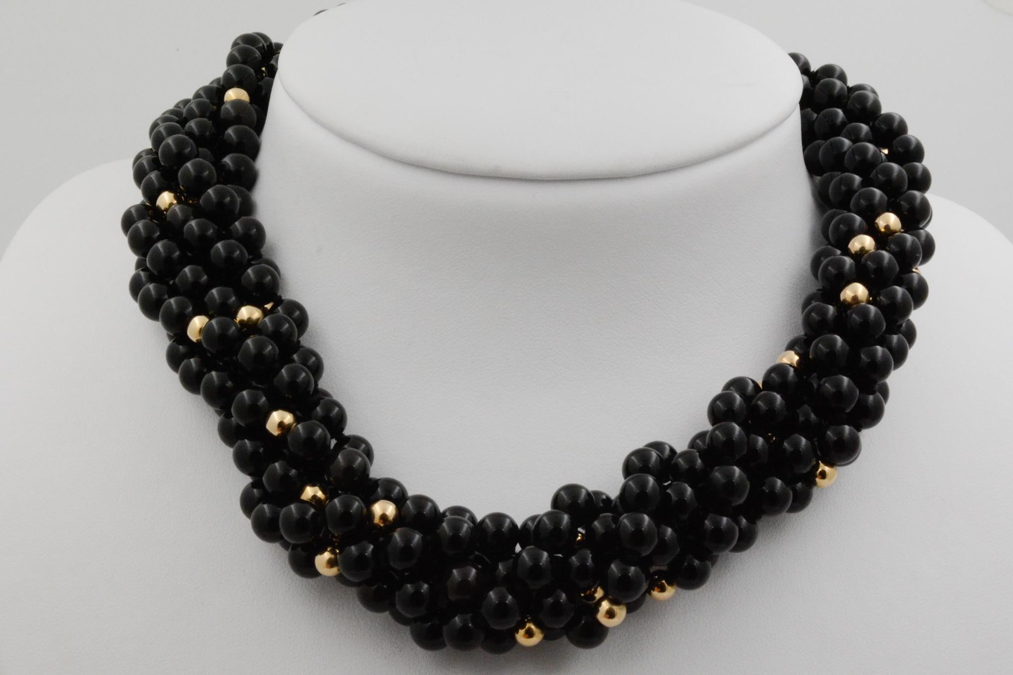Crafted with an 18K yellow gold cylinder grooved clasp, this unique six strand piece features 7.18 x 4.20 mm round-shaped rich black onyx beads and 14K yellow gold beads. The beaded strands measure to 18.5