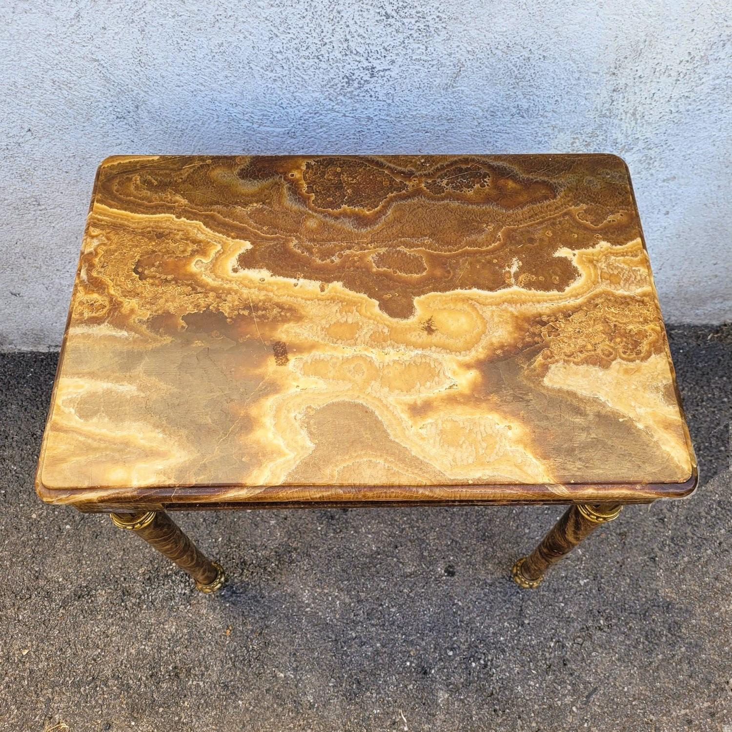 Petite table entièrement en onyx brun dont la ceinture est décorée de frises en bronze avec des bébés musiciens.

Les 4 pieds sont vissés et peuvent donc être facilement démontés

Petits éclats et anciennes restaurations

Hauteur 61cm
54.5 x 36.5cm