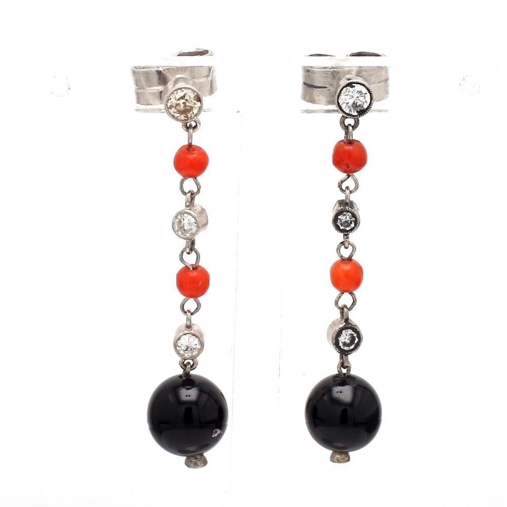 Orecchini pendenti in onice, corallo e diamanti in platino

Questi eleganti orecchini a goccia sono caratterizzati da onice nera e corallo rosso vibrante, impreziositi da diamanti scintillanti, il tutto incastonato nel platino. Peso totale: 5,3