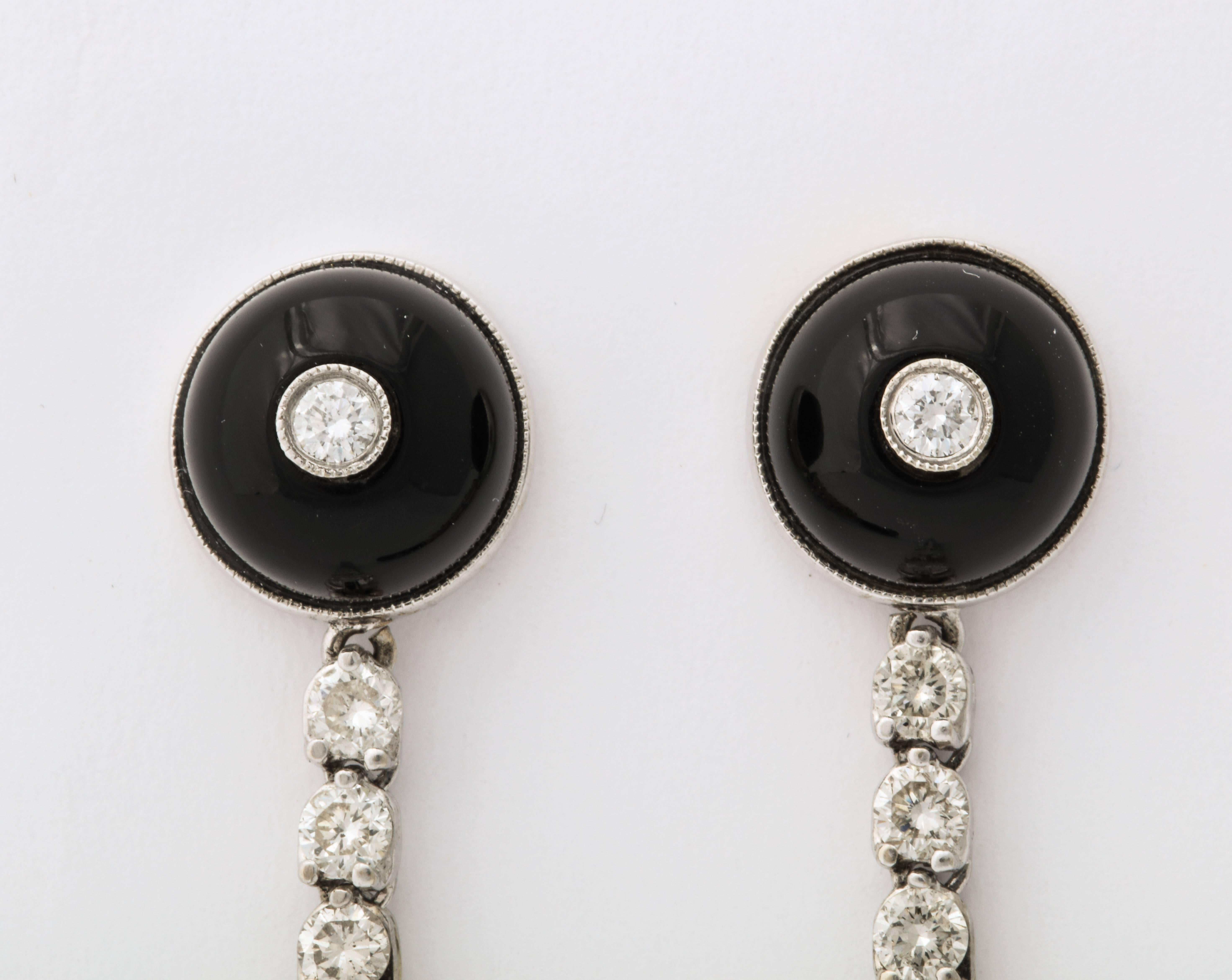 A stunning  pair of French Art Deco onyx and diamond drop earrings. A onyx stud with a diamond holds a chain of round diamonds set in platinum and ending in onyx teardrop pendants. 
