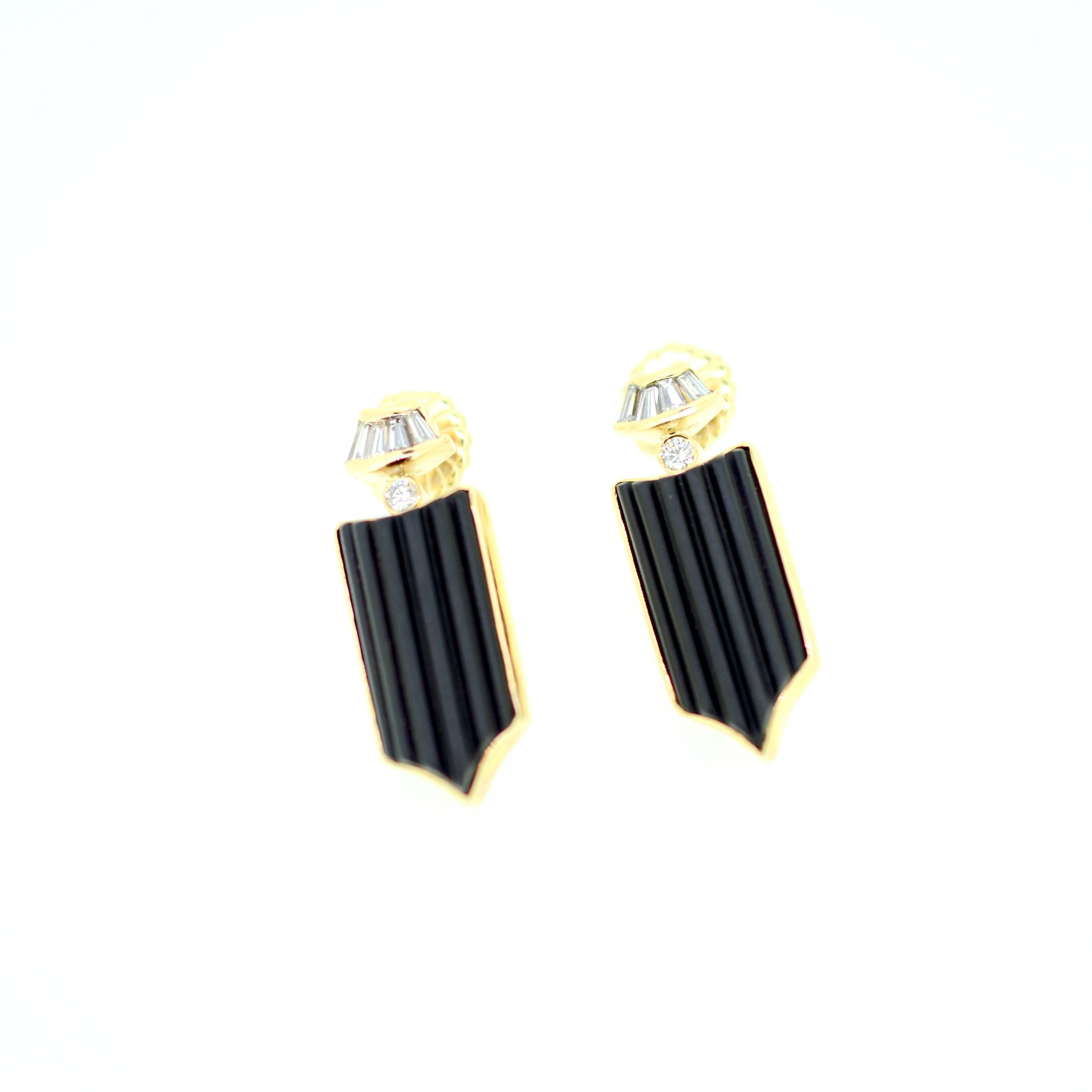 Bold black onyx and diamond pierced earrings. Hand carved and cast set with carved fluted pieces. 21.5mm x 12mm. Two .06ct round diamonds (.12ct total weight). .05 total weight diamond baguettes with extra large backs.