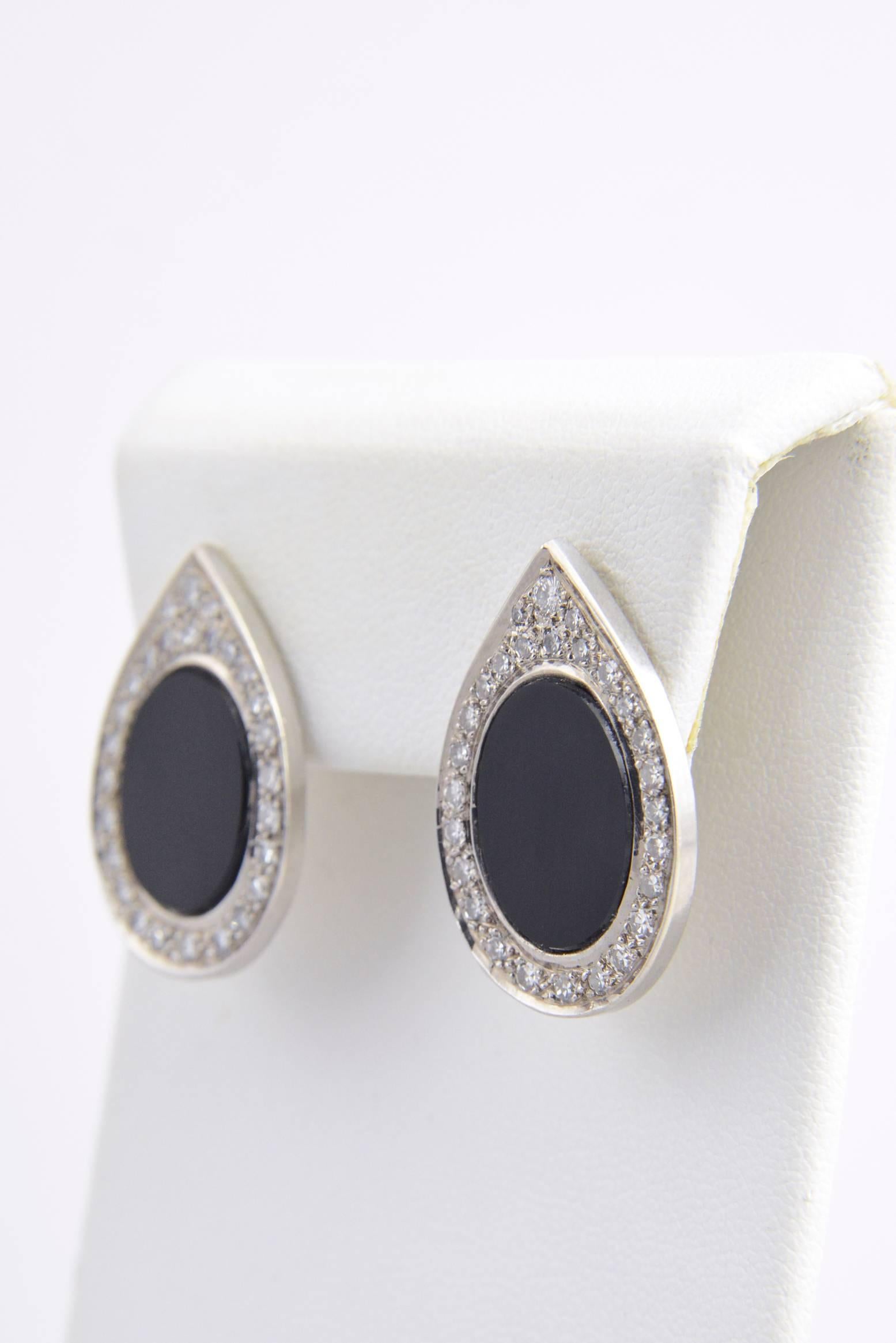 Elegant earrings featuring an oval onyx set in a platinum and diamond frame pear shaped teardrop frame. Diamonds count is approximately 1.75ct.  These earrings have a post back.