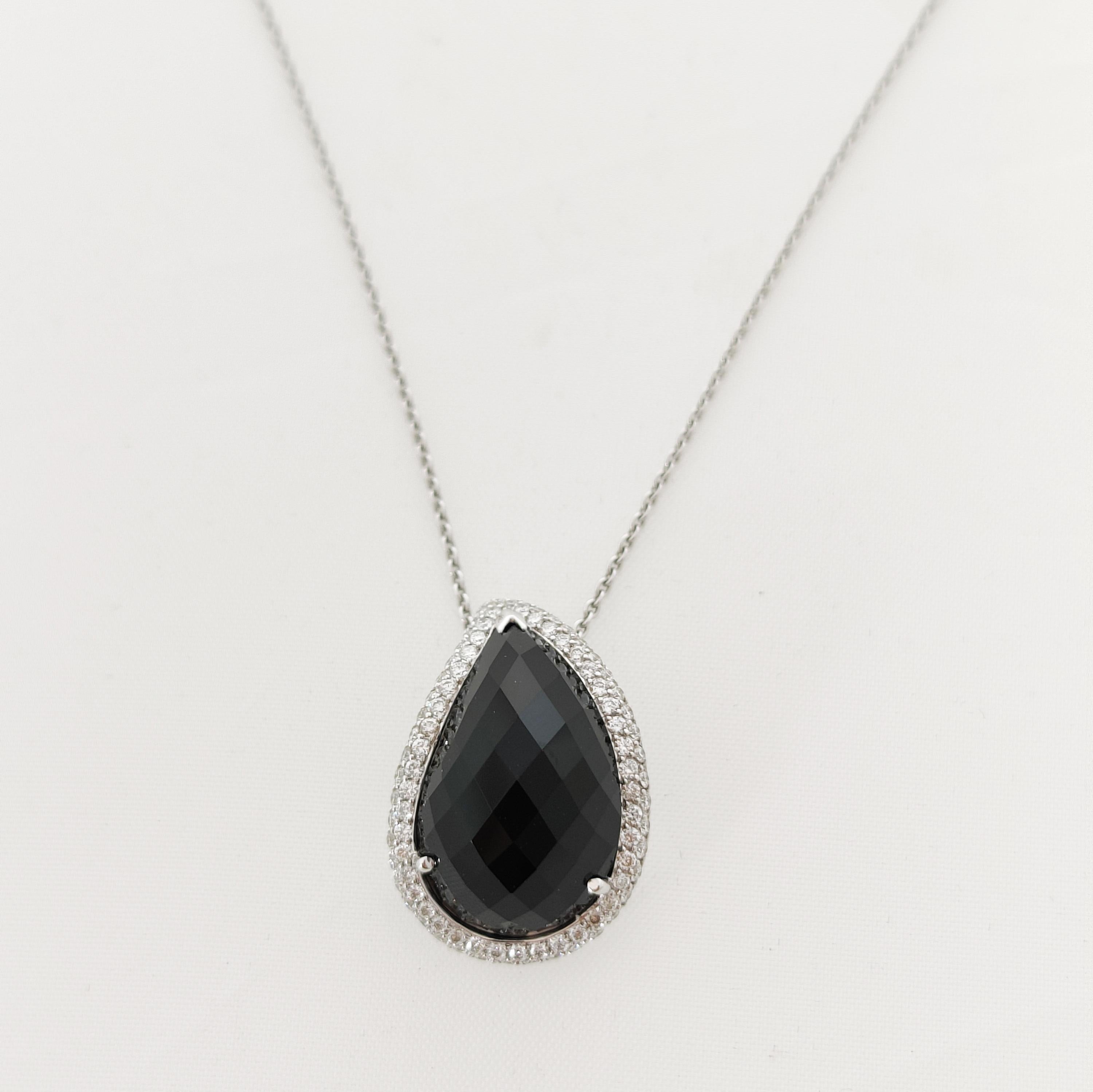 Paisley drop onyx and diamond pendant in 18 karat white gold. Glamorous style pendant with a paisley shaped multi-faceted black onyx, held by a halo of round cut diamonds. All of the smaller round cut diamonds have a total carat weight of 0.52ct and