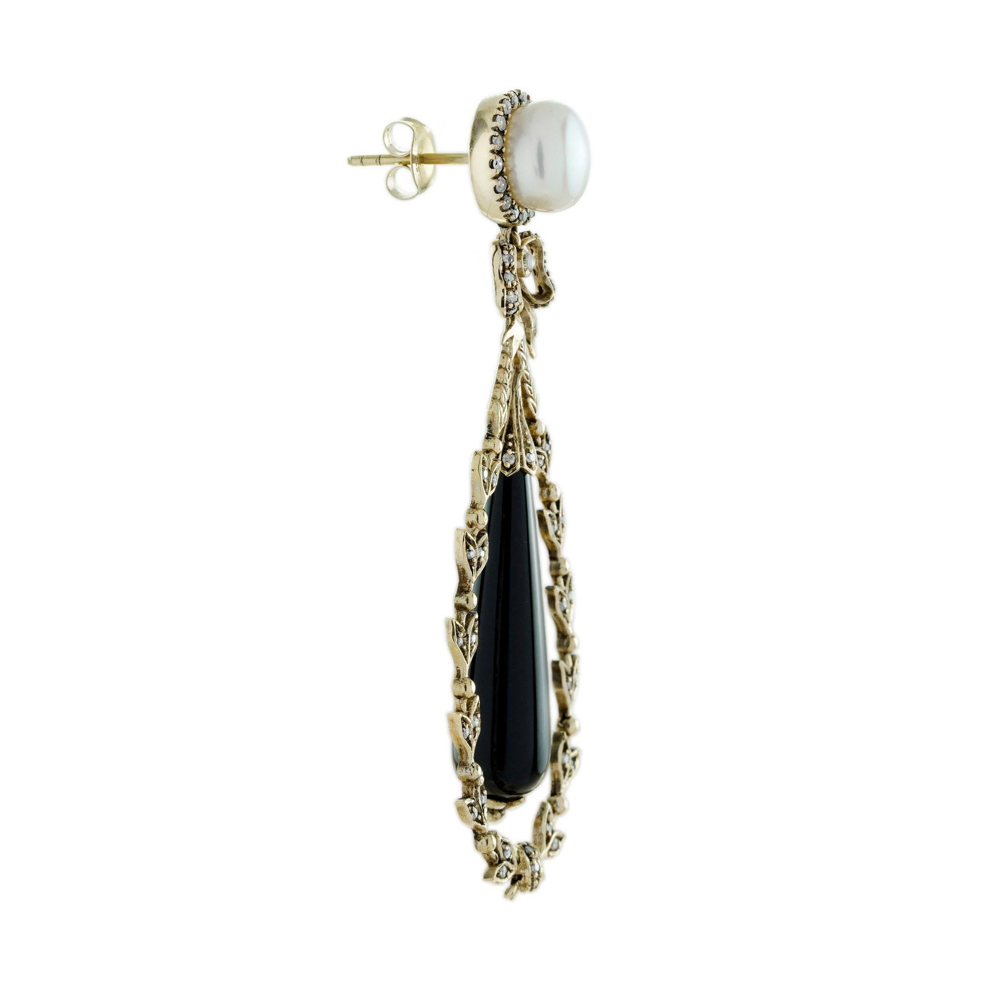 These Onyx and Pearl Art Deco Style Drop Earrings combine classic elegance with bold vintage flair. A luminous round pearl sits at the earlobe, while a sleek onyx drop hangs gracefully at the center of a gold floral-inspired design. The striking
