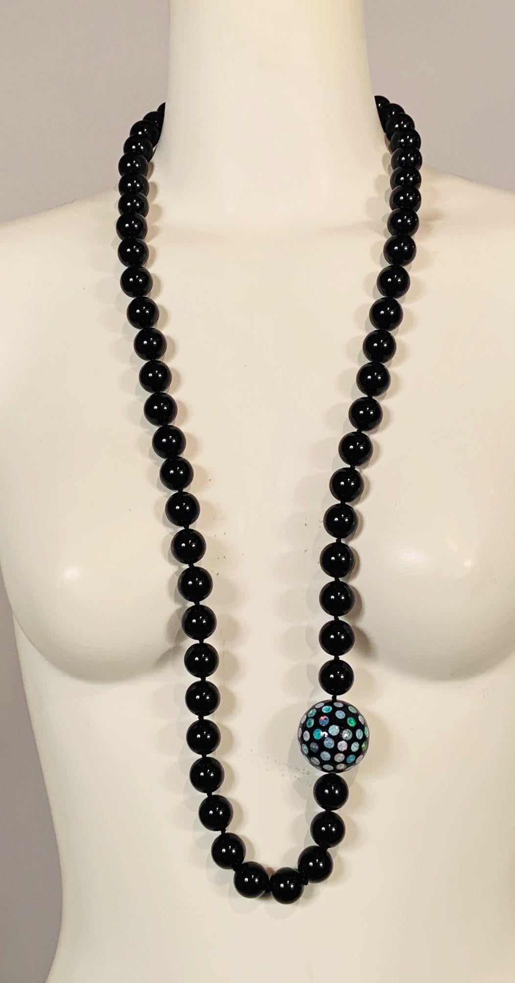 Glistening onyx beads are embellished with a large scale onyx bead studded with brilliant eye catching Australian opals.  The opals sparkle in the light beautifully and the colors range from pale blue, violet, turquoise to pink and deep red. The