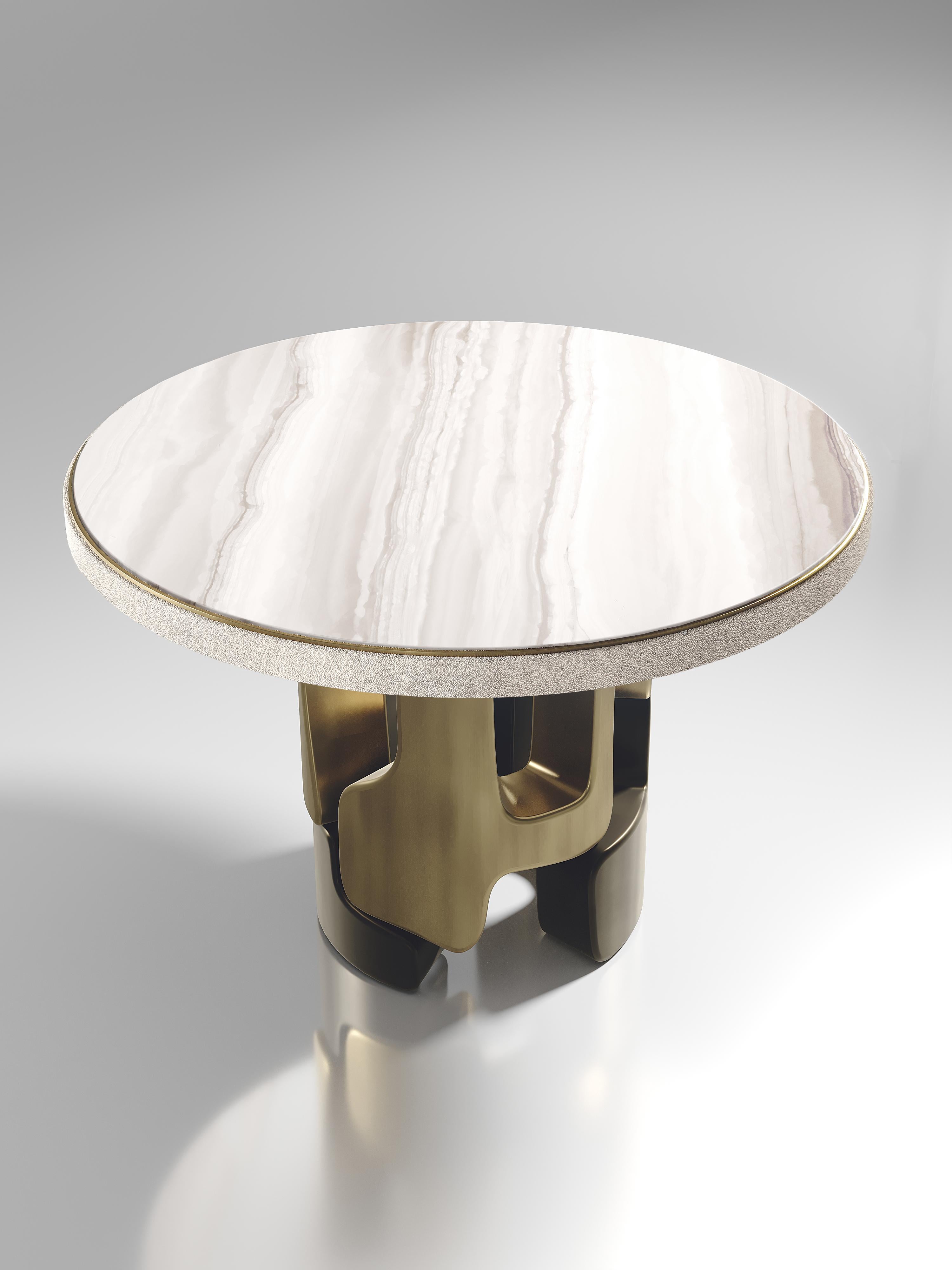 The Apoli breakfast table by Kifu Paris is both dramatic and organic its unique design. The onyx top sits on an ethereal geometric and sculptural bronze-patina brass base. This piece is designed by Kifu Augousti the daughter of Ria and Yiouri