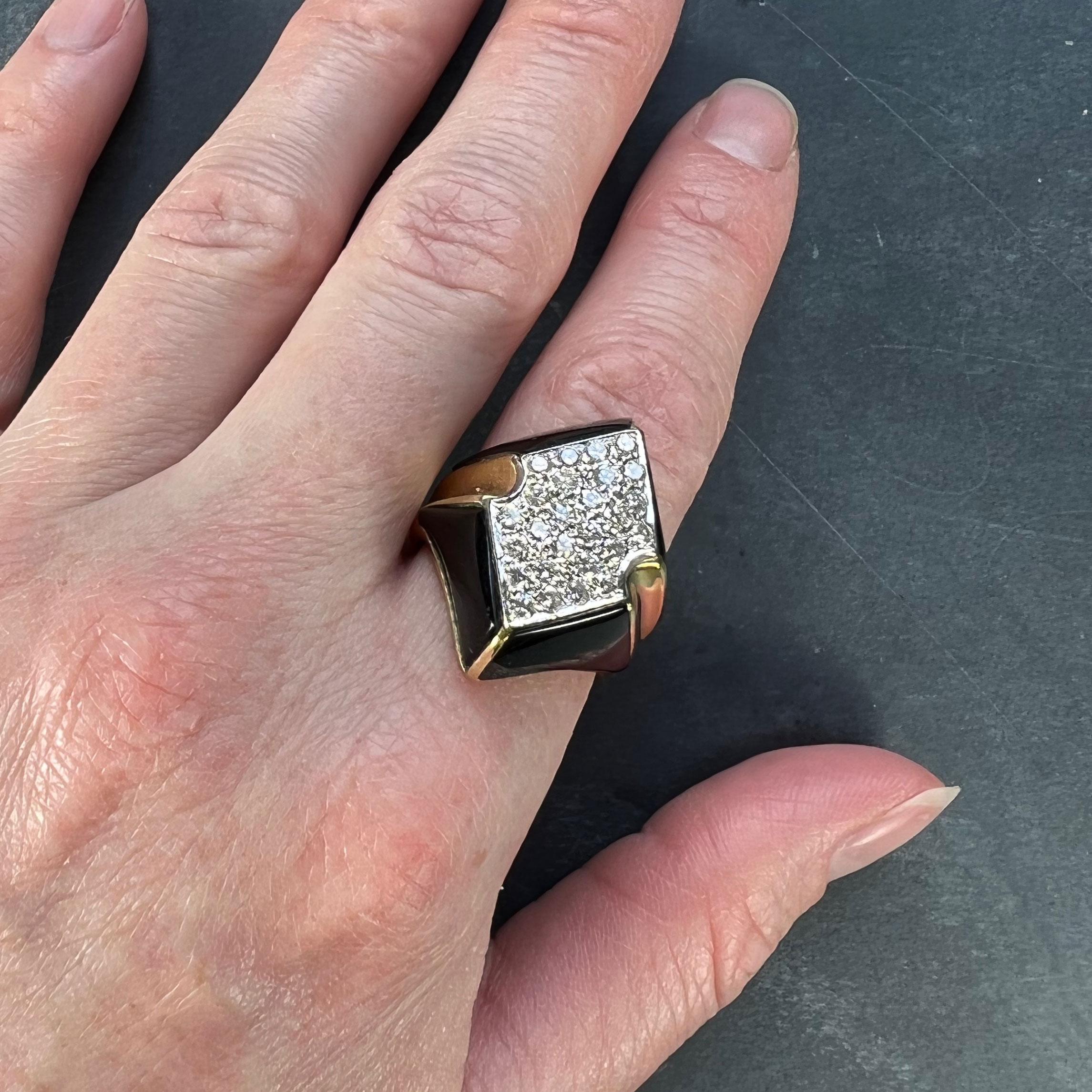 A very smart 18 karat yellow gold cocktail ring set with a panel of 26 white diamonds with a total approximate weight of 1.56 carats to an onyx panel surround. 

Ring Size: 7 (US), N (UK)
Dimensions: 2.6 x  2.3 x 2.8 cm
Weight: 11.79 grams
