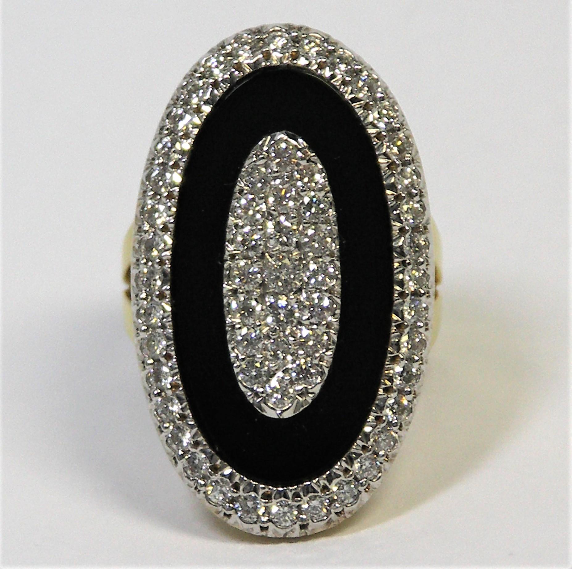 Made of 18K Yellow Gold with a large oval shaped, onyx slab cut into
the ring, surrounded by pave set diamonds weighing an approximate
total of 1.70CT of overall G Color and VS1 Clarity. Notice the detailed
design sides of the ring. Measures 1 3/8