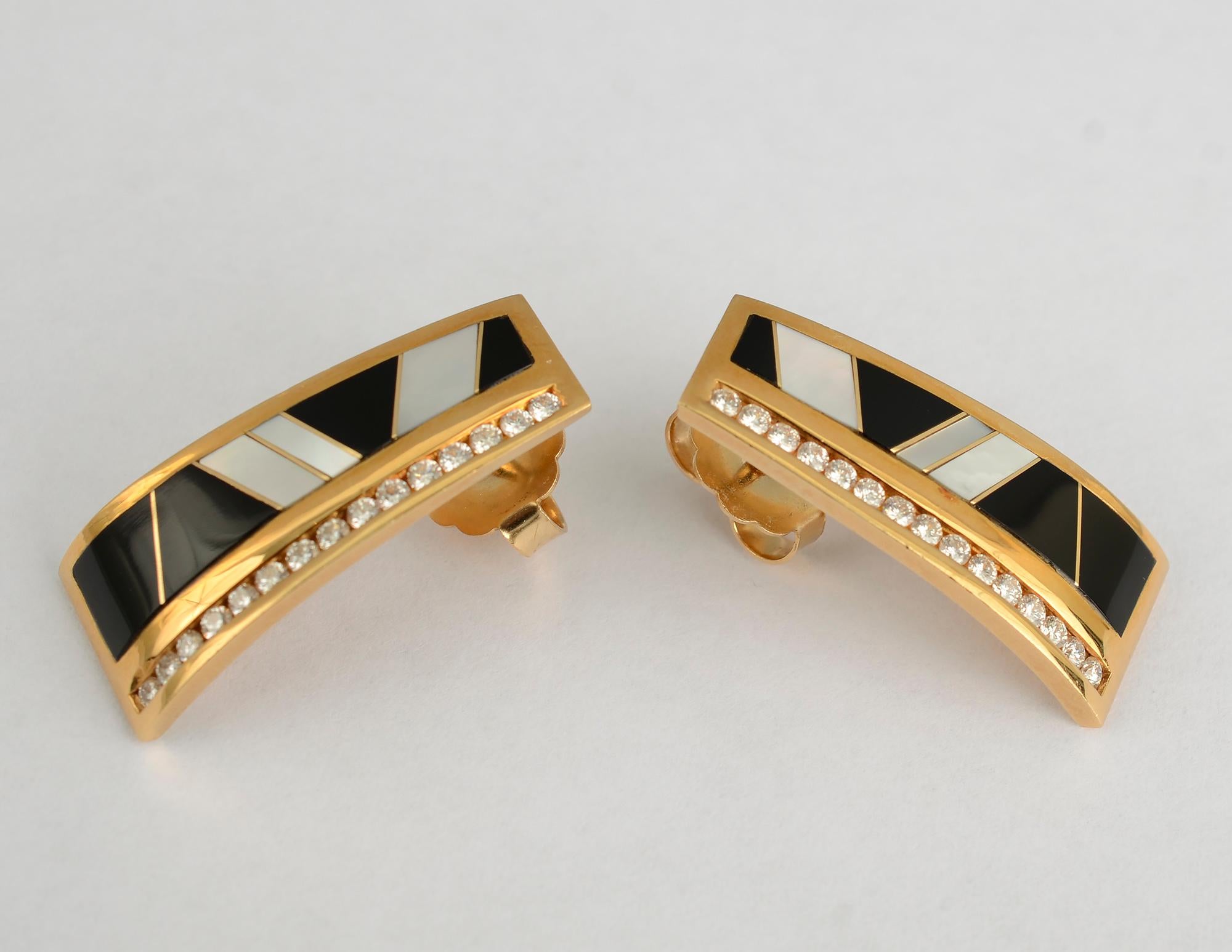 Geometric design earrings of black onyx and mother of pearl, softened by a row of diamonds. The earrings are slightly convex. They measure 
1 1/4 inches in length and half an inch in diameter across the bottom. The top is 3/8