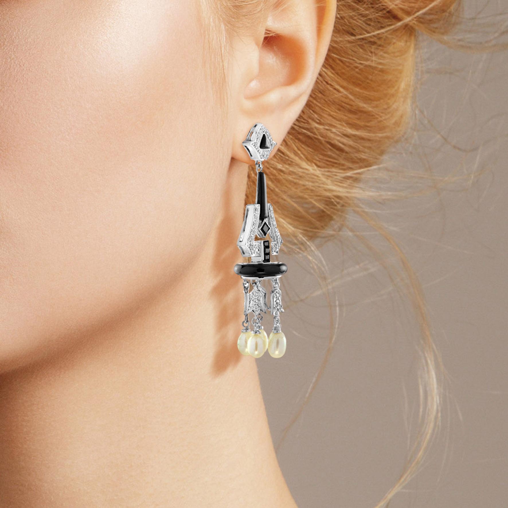Présentées en noir et blanc, ces rares et ravissantes gouttes d'inspiration Art déco, élégamment conçues et fabriquées à la main en or blanc, se terminent par une danse de perles naturelles lustrées. Les diamants façonnés avec art sont rehaussés
