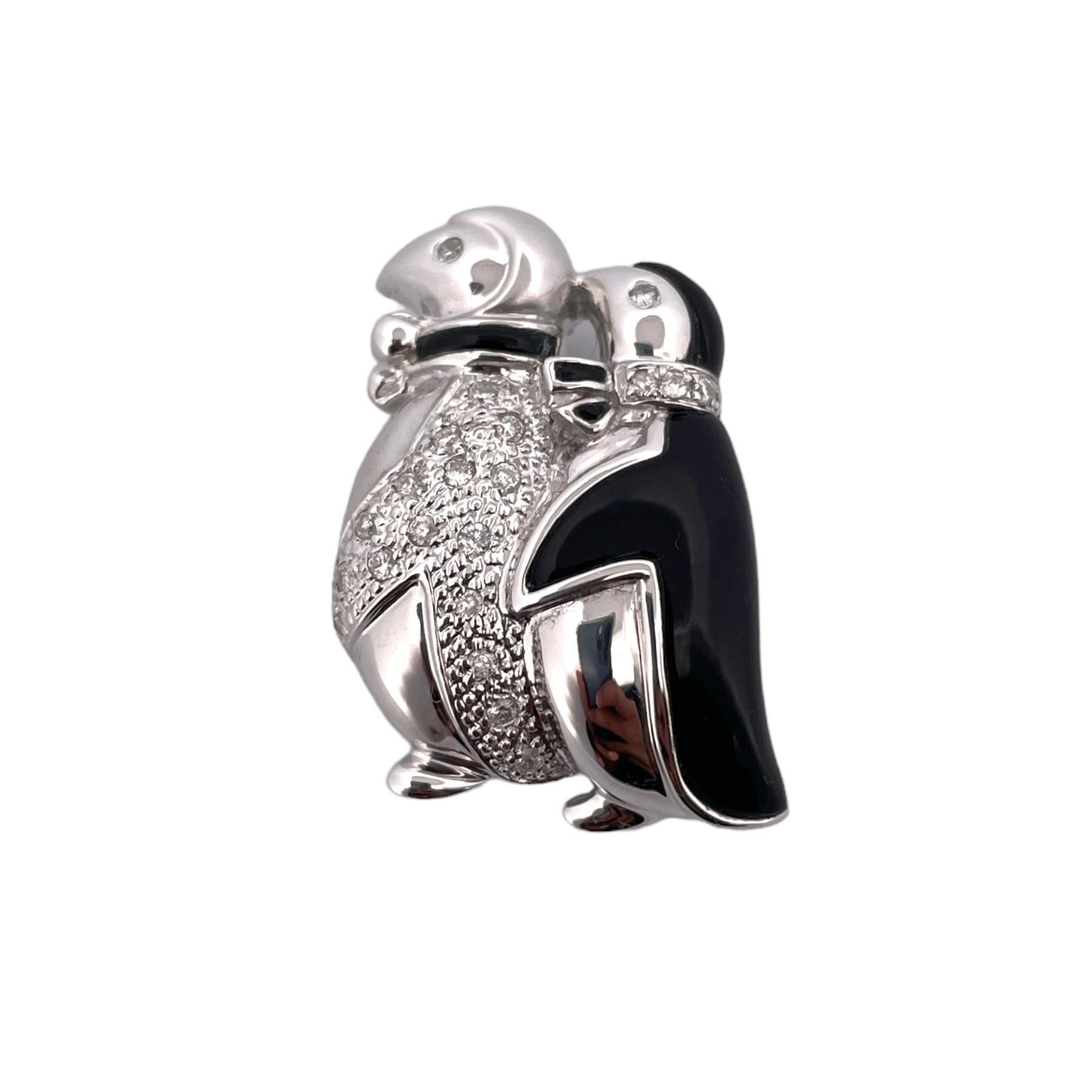 Zelebrieren Sie die Schönheit der Natur und die Eleganz mit dieser Brosche aus Onyx und Diamanten mit einem entzückenden Pinguinpaar, das mit einem Gesamtkaratgewicht (TCW) von 1,00 in Diamanten verziert ist.  Er ist aus exquisitem 14-karätigem