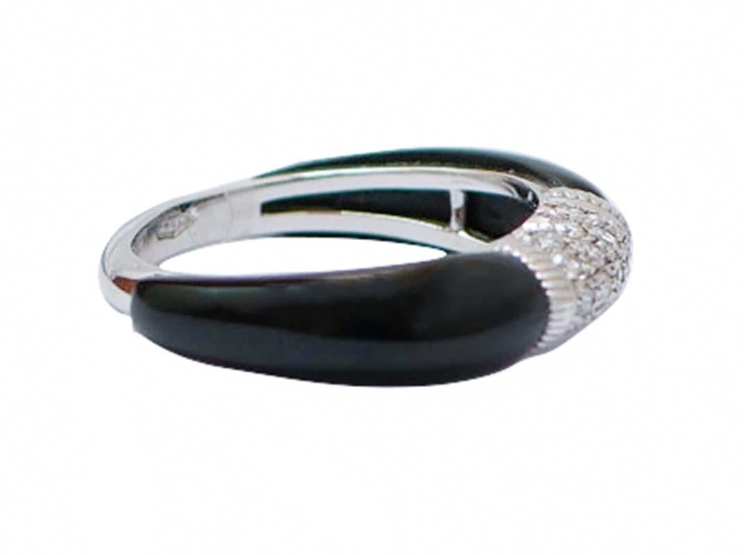 Elegante anillo de estructura de oro blanco de 18 kt montado con diamantes en la parte central y, lateralmente, ónice.
Este anillo fue totalmente hecho a mano por maestros orfebres italianos y está en perfectas condiciones.
Diamantes 0,42 ct
Ónice