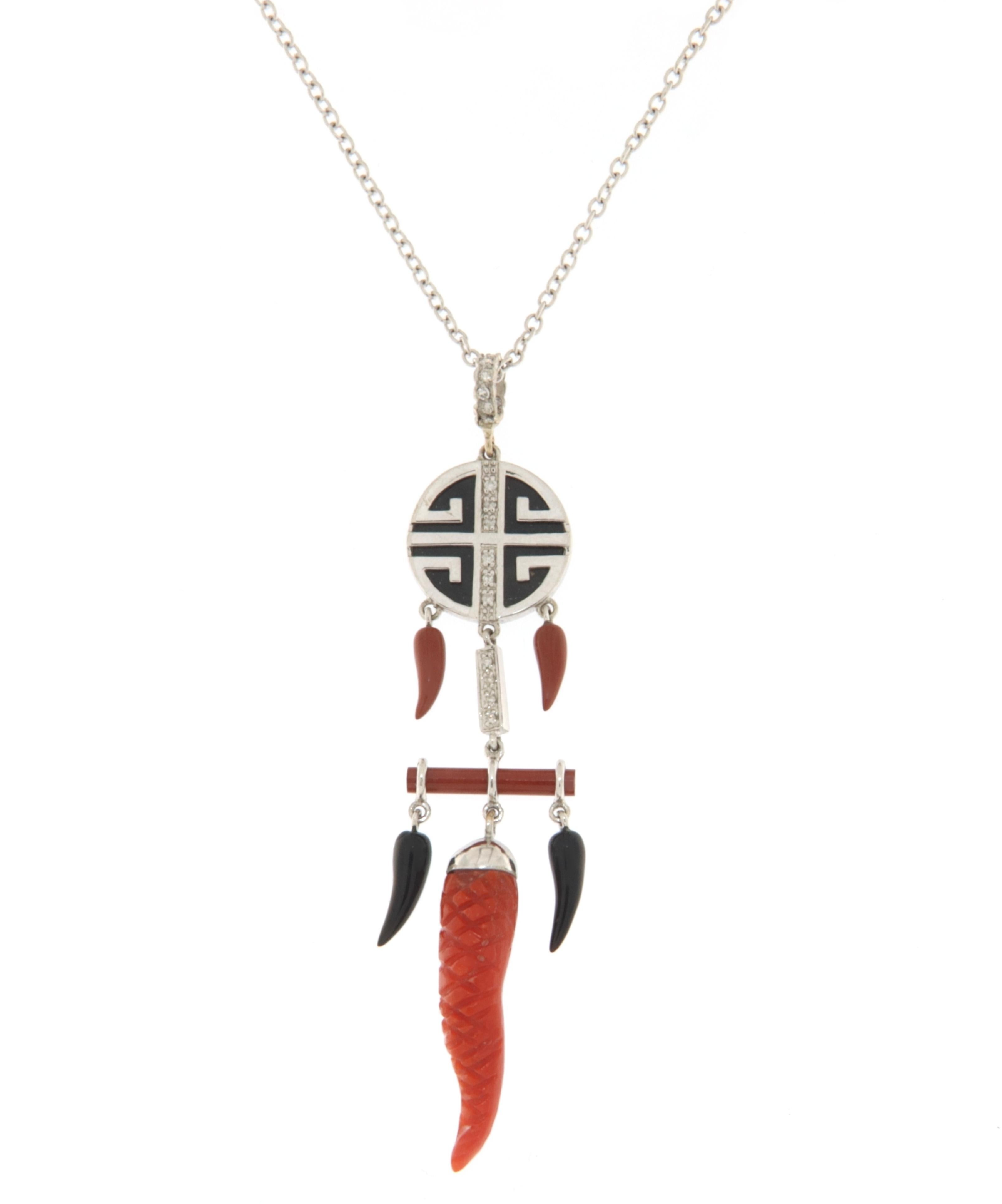 This striking pendant necklace in 18-karat white gold is a bold statement piece that effortlessly captures the essence of both modern style and ancient symbolism. The pendant is adorned with three natural coral horns, each one showcasing the vibrant