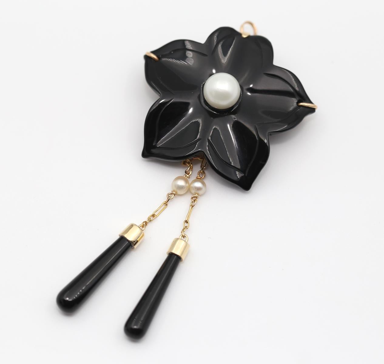 Broche fleur en onyx pendentif perles or 14K, 1930

Fleur d'onyx avec deux pendentifs détachables en perle et onyx. Or 14K. Créée vers les années 1930.

Un objet très fin et très élégant. Il peut être porté en broche ou en pendentif. Une boucle