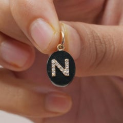 Charme con onice e diamante naturale, in oro giallo massiccio 14k, con iniziale "N"