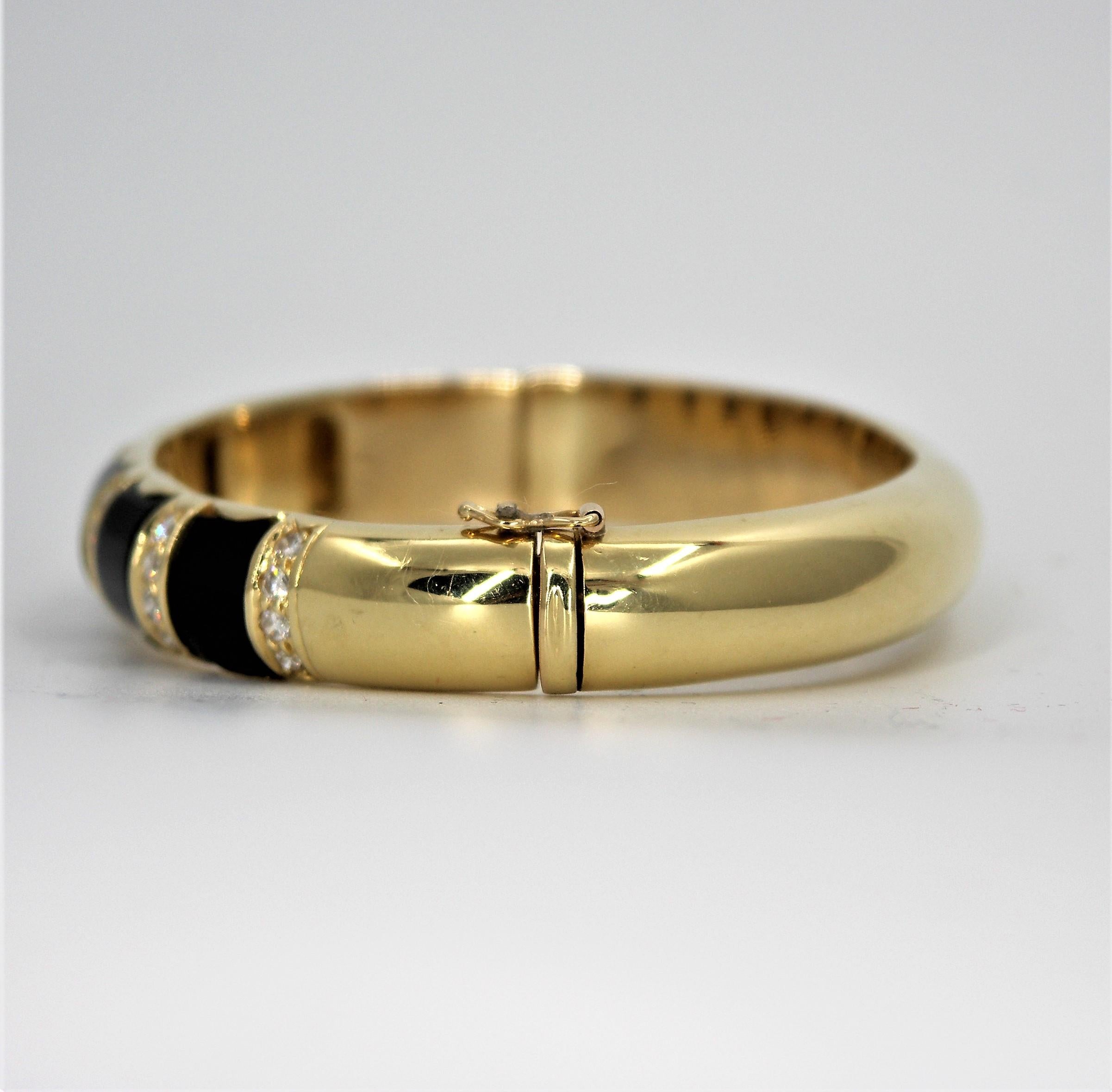 Made of 18K yellow gold, this oval shaped bangle is  set with five onyx sections and 
with 24 round brilliant cut diamonds weighing an approximate total of 1.20CT of overall 
G color and VS1 clarity. Hinged on one side and with a figure 8 safety on