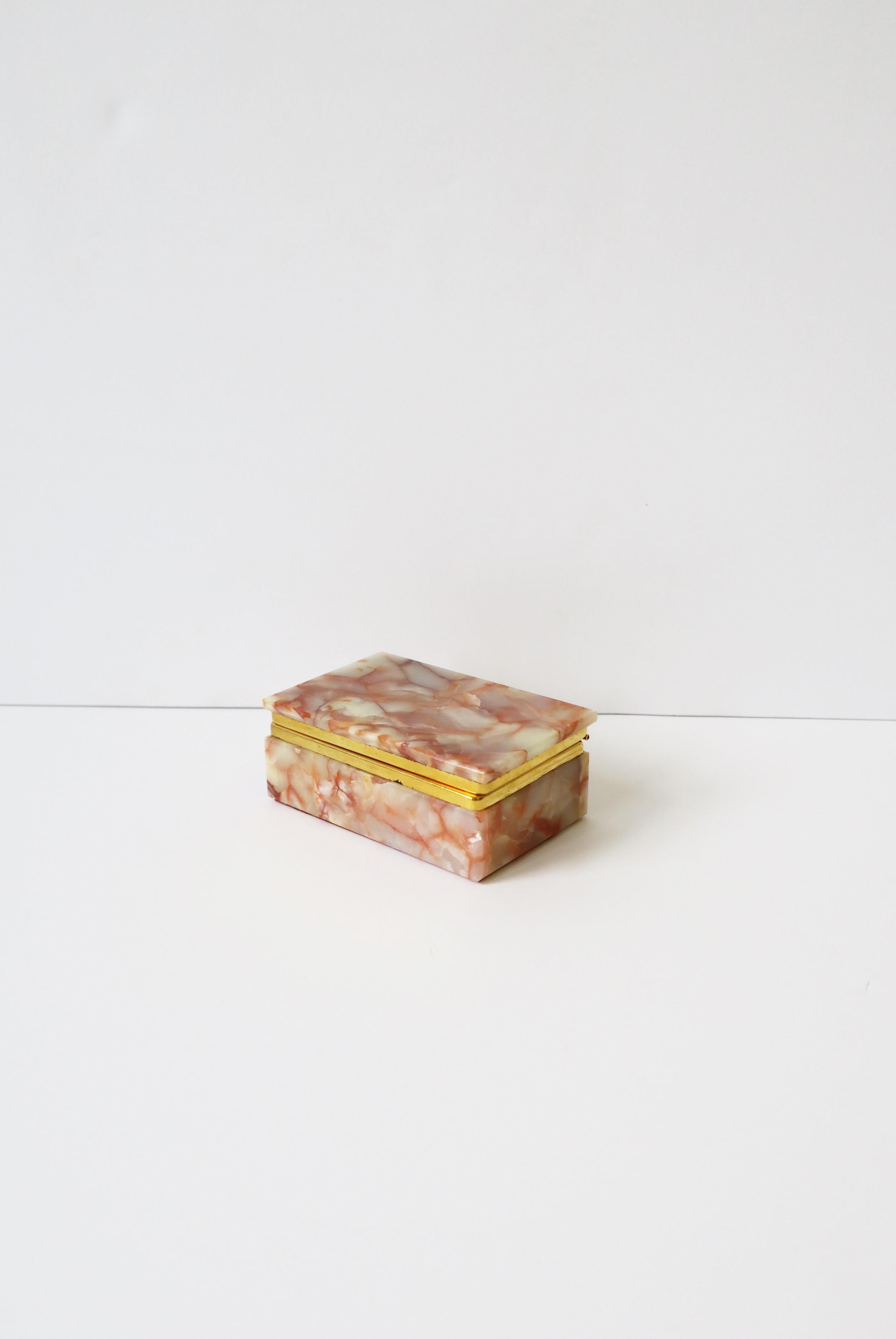 An Italian pink and cream onyx marble jewelry box with brass plated hinge, circa mid-20th century, Italy. A great piece for a desk, vanity, nightstand, dresser, etc., to hold small items or jewelry as demonstrated. Dimensions: 4.38