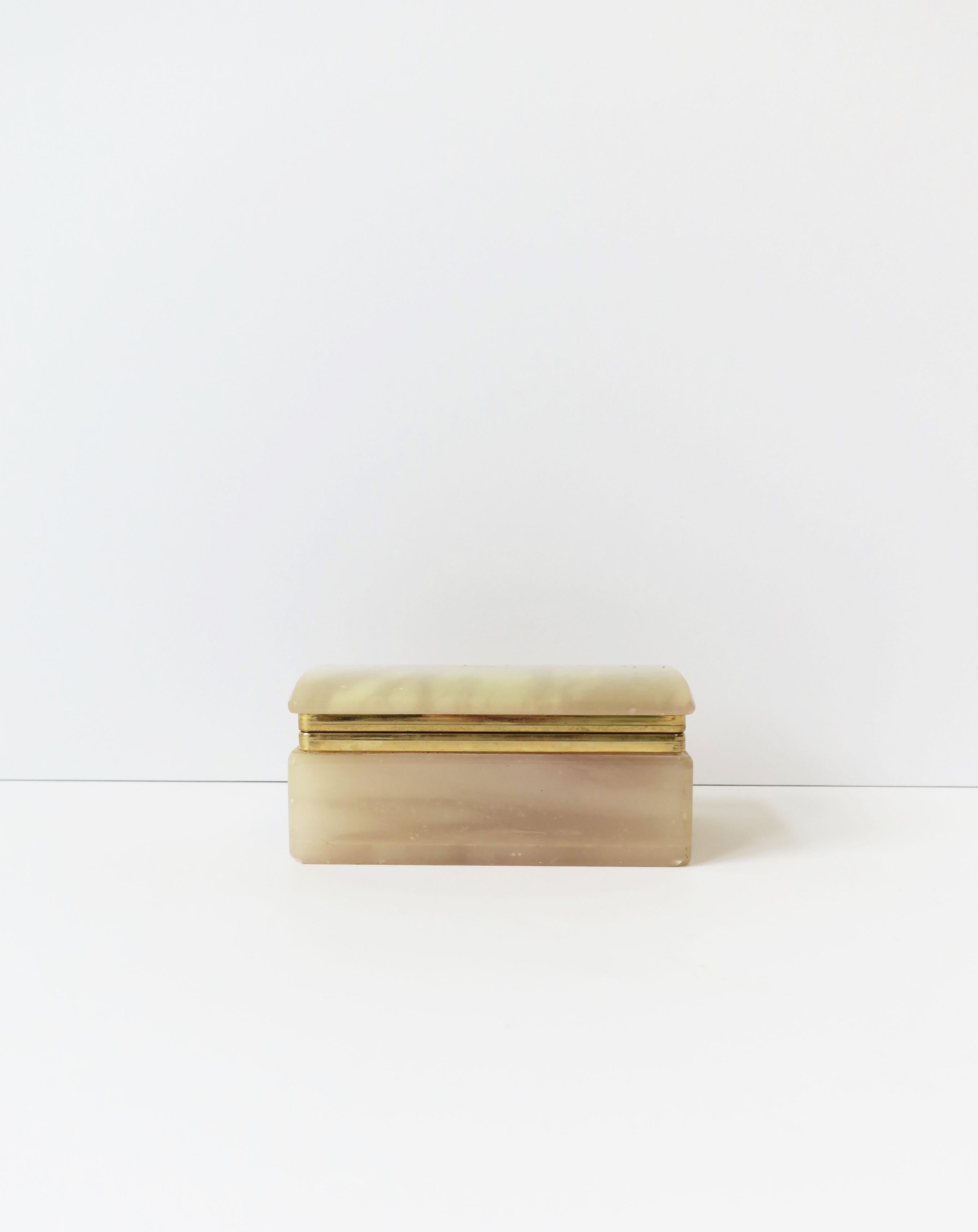 An onyx and brass plated rectangular box, circa late-20th century. A great piece for jewelry or other small items on a dresser, vanity, nightstand table, closet, desk, etc. Dimensions: 2.75