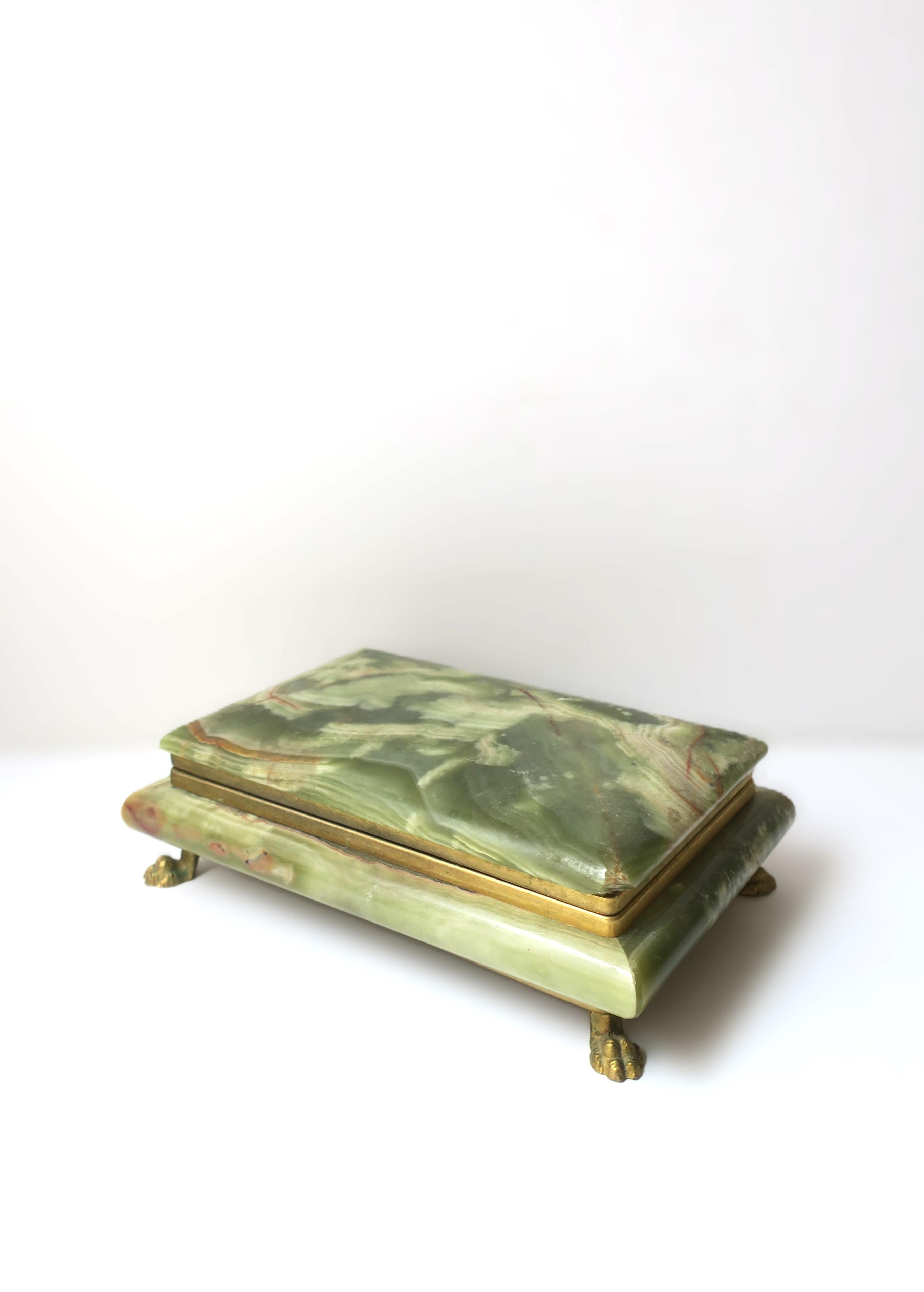 A substantial Italian green onyx marble and gold gilt metal jewelry or decorative box, in the Empire style, circa mid-20th century, Italy. Onyx is a combination of green hues finished a gold gilt metal hinge and lion paw feet base. Beautiful as a