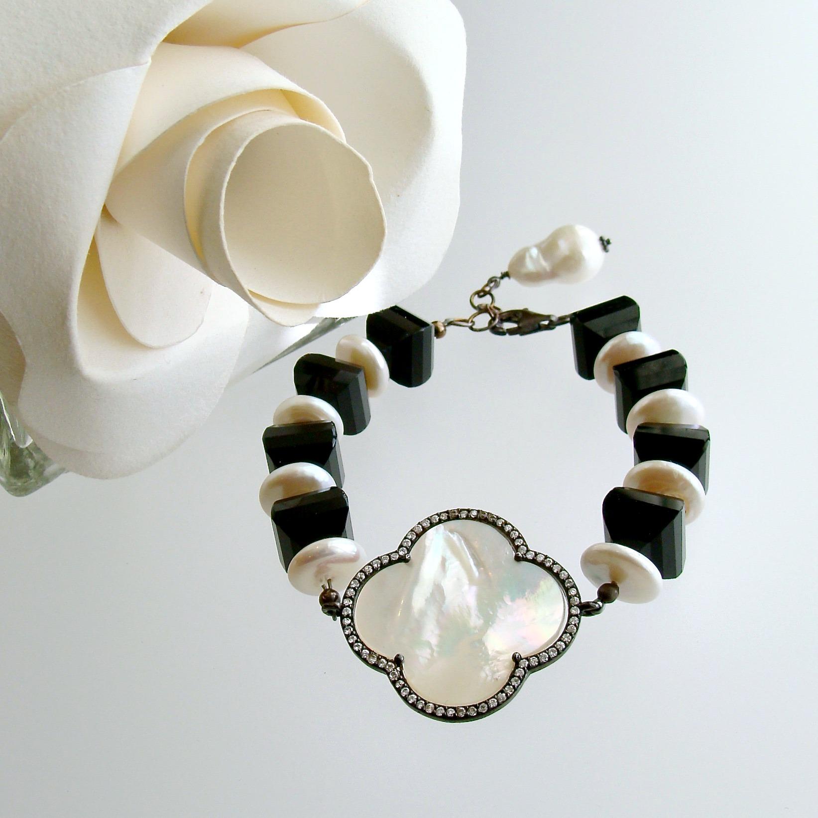 There is simply nothing as refreshing as a simplistic design rendered in black and white.  This bracelet of highly polished black onyx lanterns alternates with creamy white coin pearls and features a mother of pearl quatrefoil accented with pave