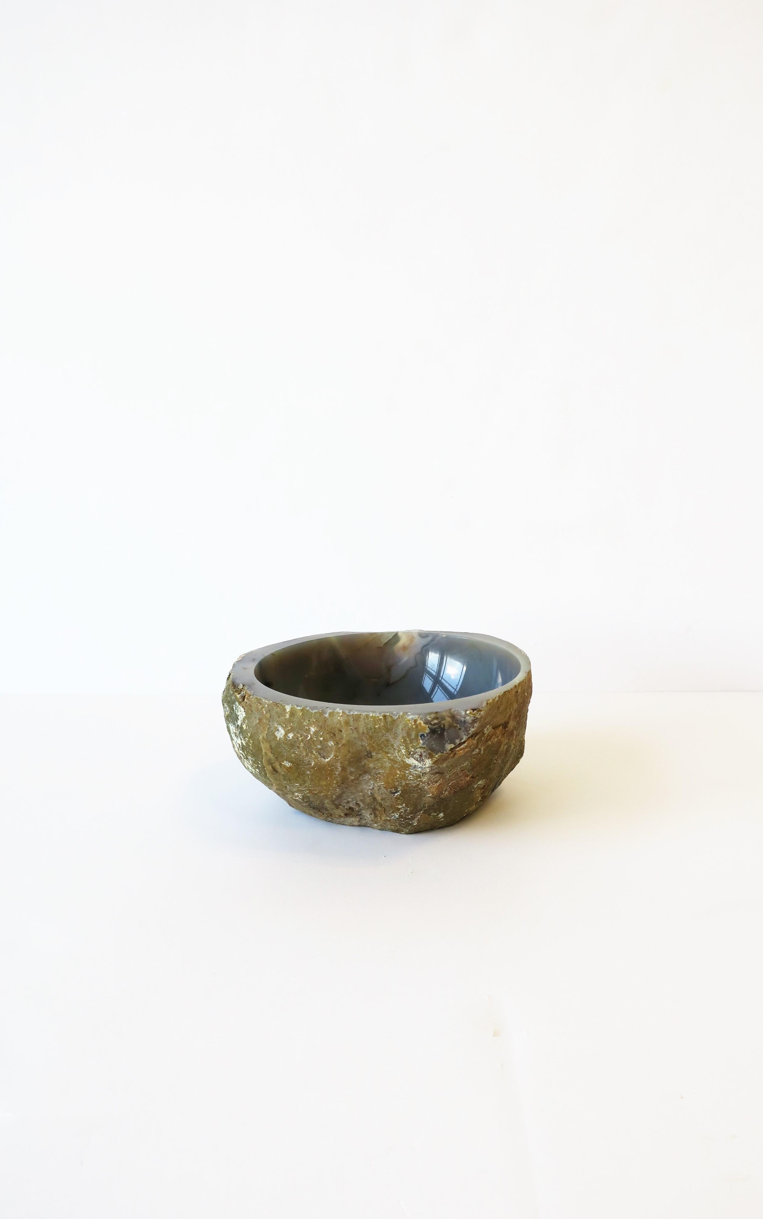 An onyx agate bowl in the organic modern style, with a raw exterior and polished smooth interior, in a blue-grey hue. 

Dimensions: 3