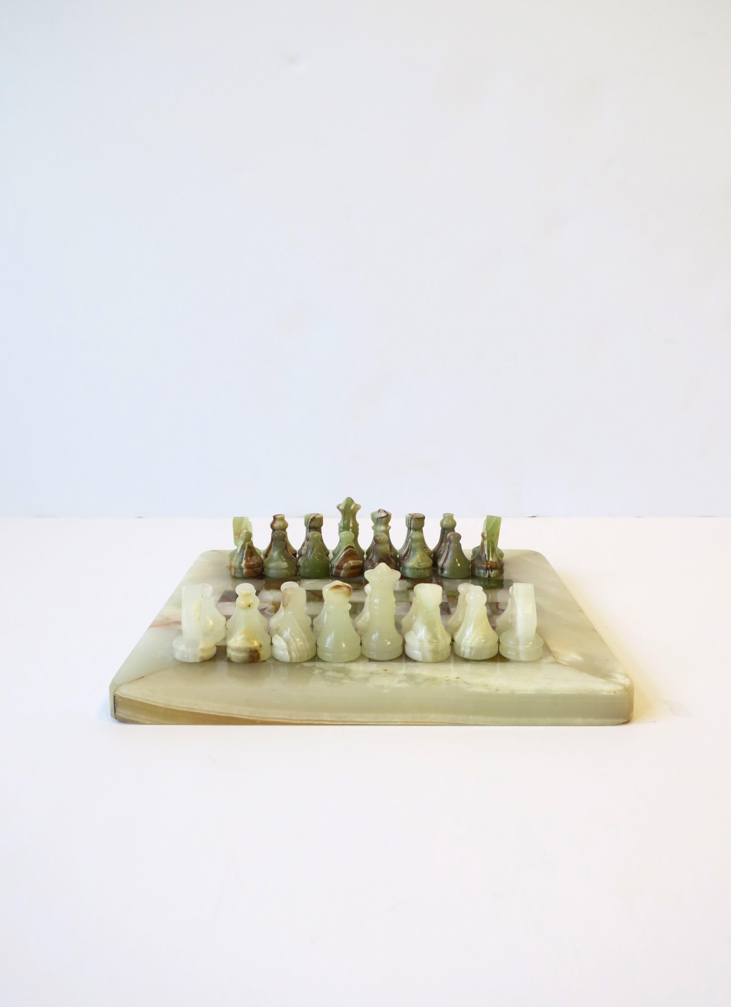 An onyx marble chess game set, circa mid to late-20th century, 1970s. Game set is hand-crafted. Game board is off-white cream and green onyx marble hues. Set includes one board and 32 pieces. Set is relatively small and a convenient size. Board