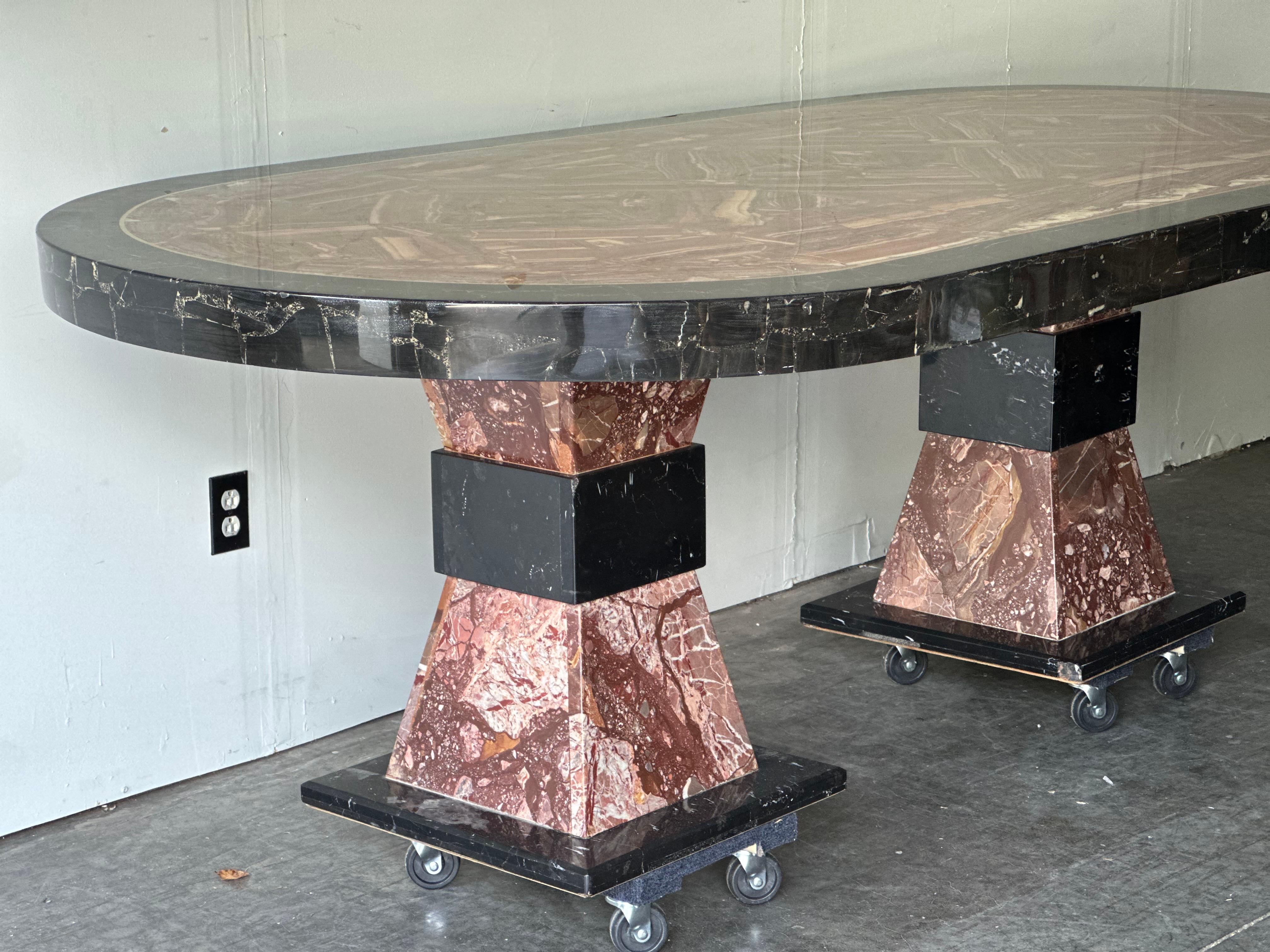 Oval onyx and marble dining table by Muller of Mexico. Large table top rests of two stone base pieces. Epoxy finish on table top has slight chips as shown in photos. Can be removed or repaired by is fine as-is. Table is displayed on flat dollies in