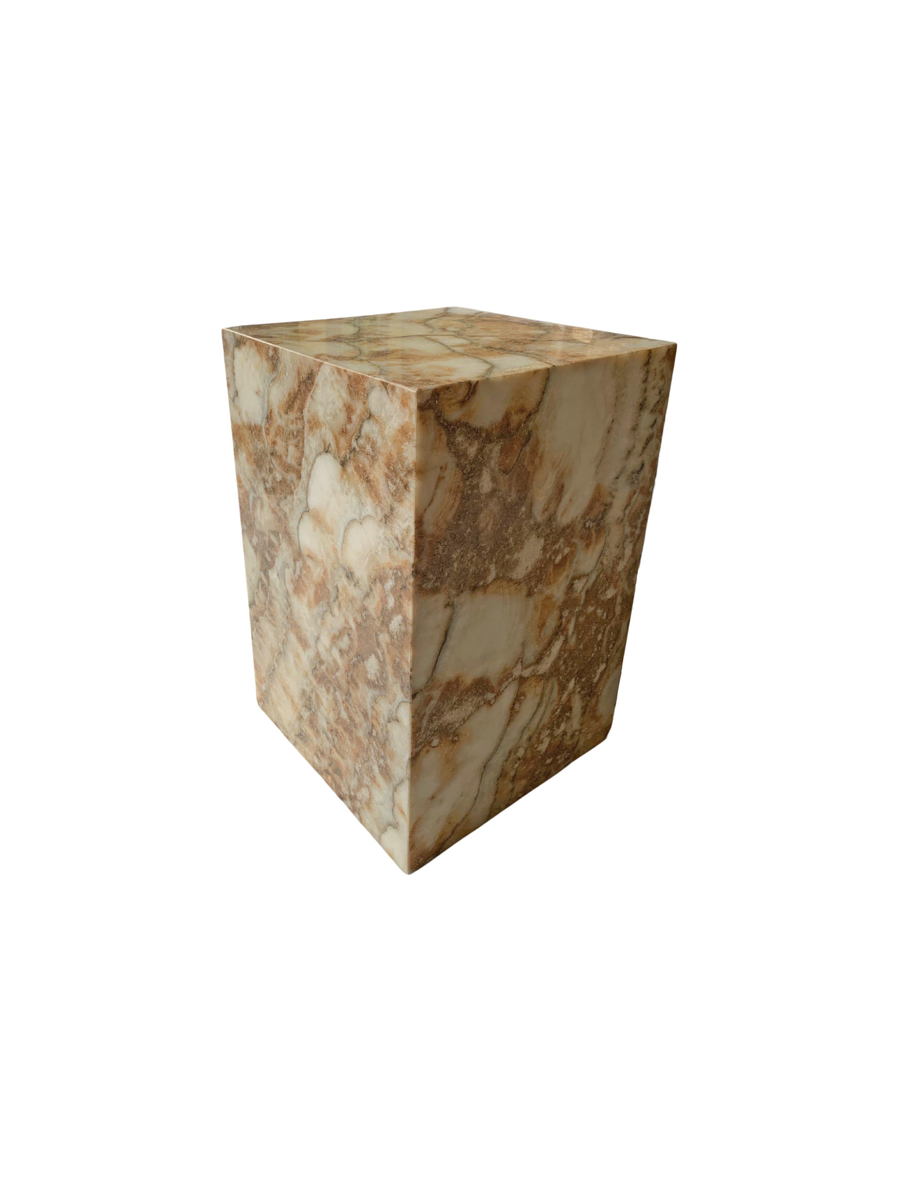 An onyx marble side table or pedestal with wonderful textures and shades. Hand-crafted by local artisans on the island of Java, this is a wonderful object to bring warmth to any space. It is hollow at its center, this is highlighted in the last