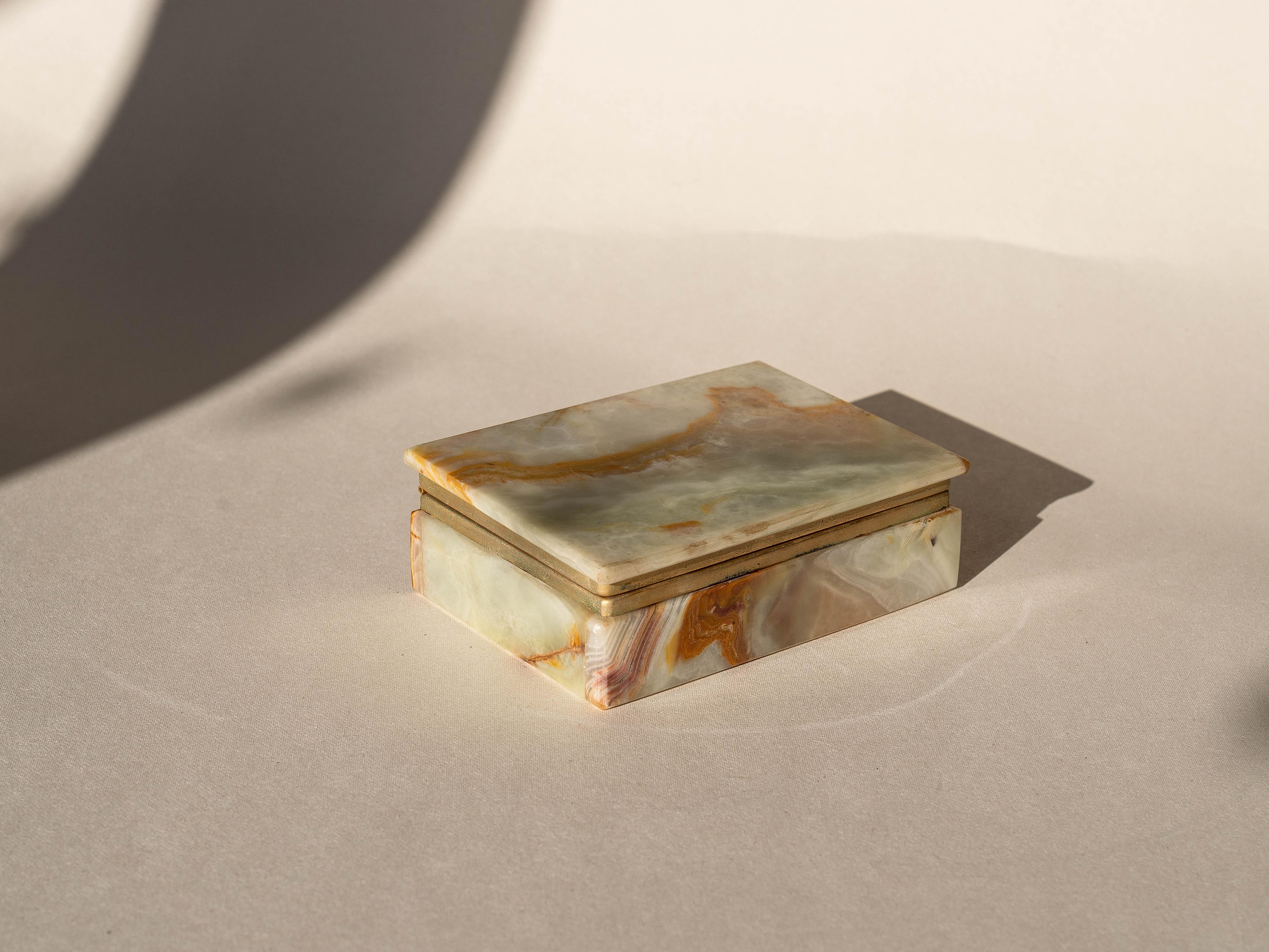 Joyero de ónice, piedra mineral y latón, Italia Años 70

Joyero o caja de baratijas decorativa muy elegante.

Construido enteramente con piedra de ónice y una bisagra de latón.

Diferentes tonos de ónice con vetas llamativas: verde claro y beige